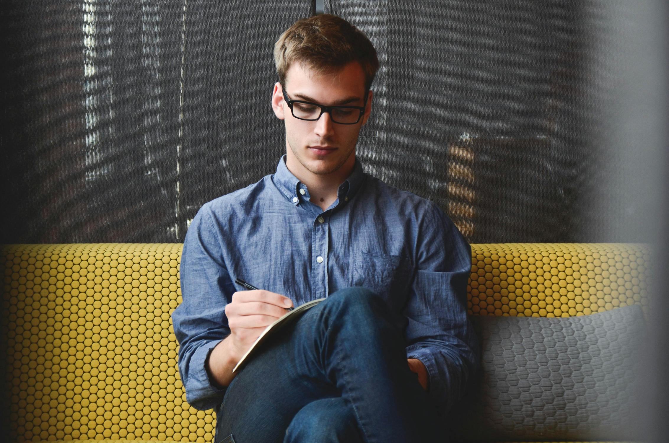 Un jeune homme en train d'écrire | Source : Pexels