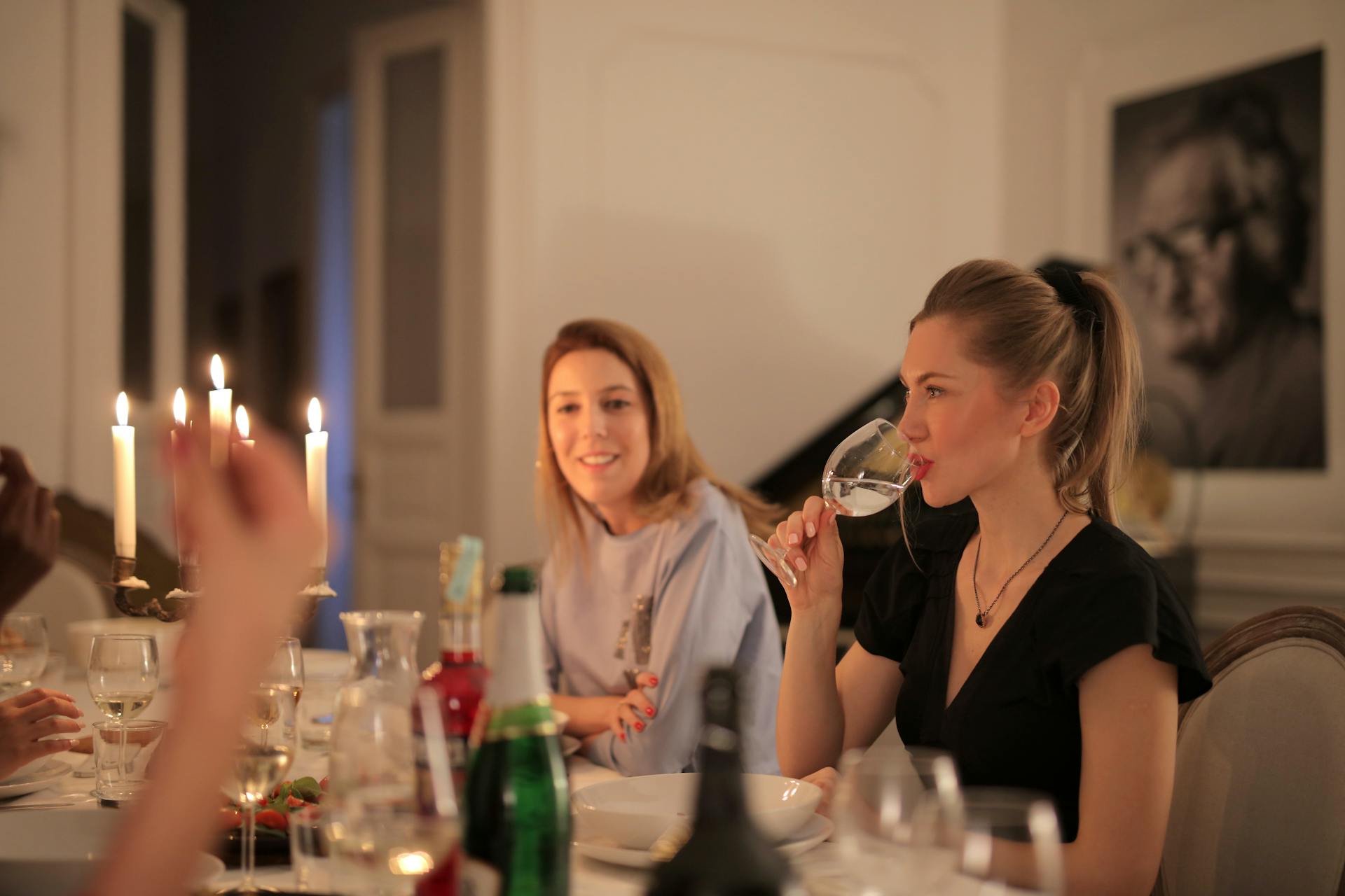 Une femme qui boit du vin tout en dînant avec ses amis | Source : Pexels