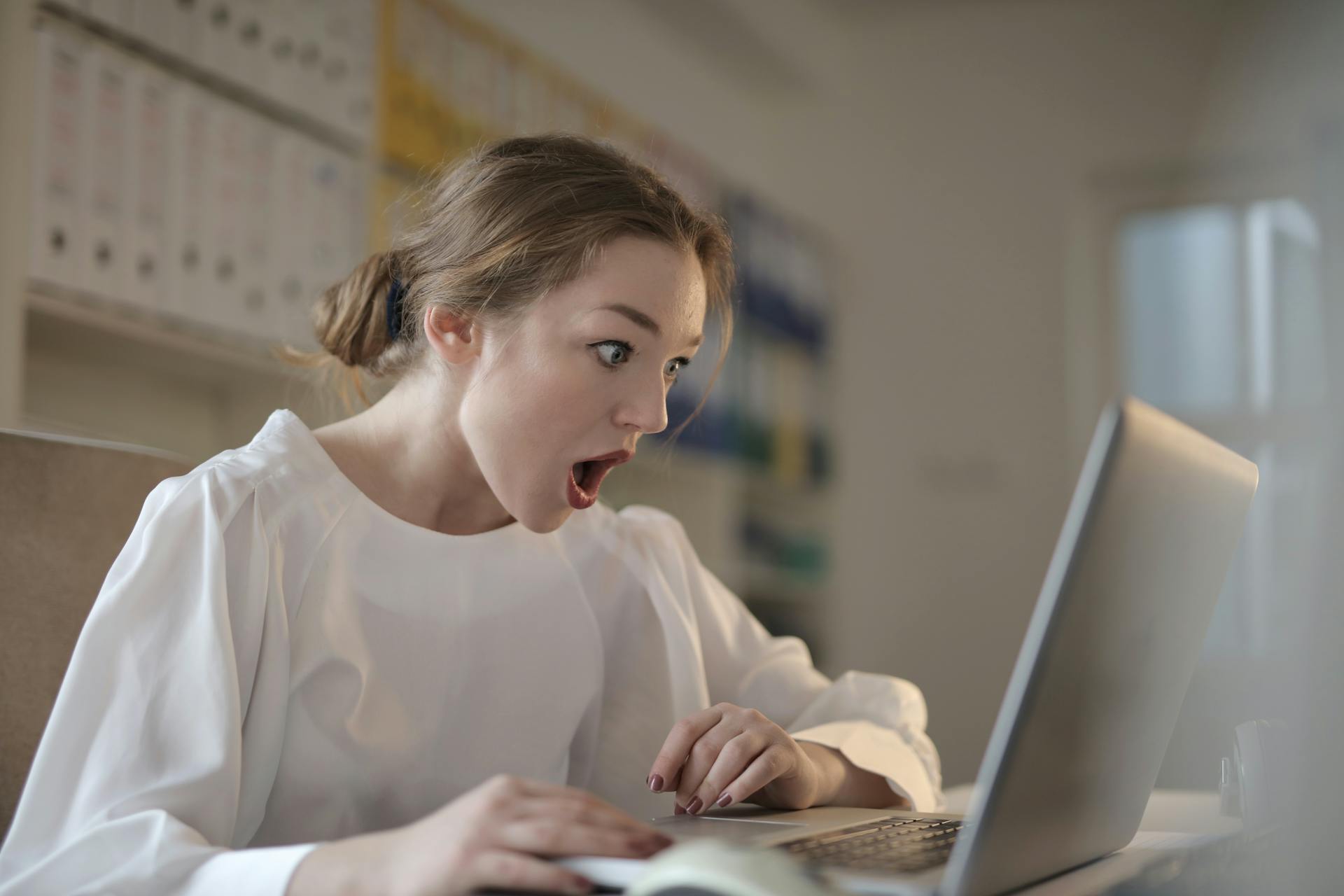 Une femme choquée alors qu'elle regarde l'écran d'un ordinateur portable | Source : Pexels
