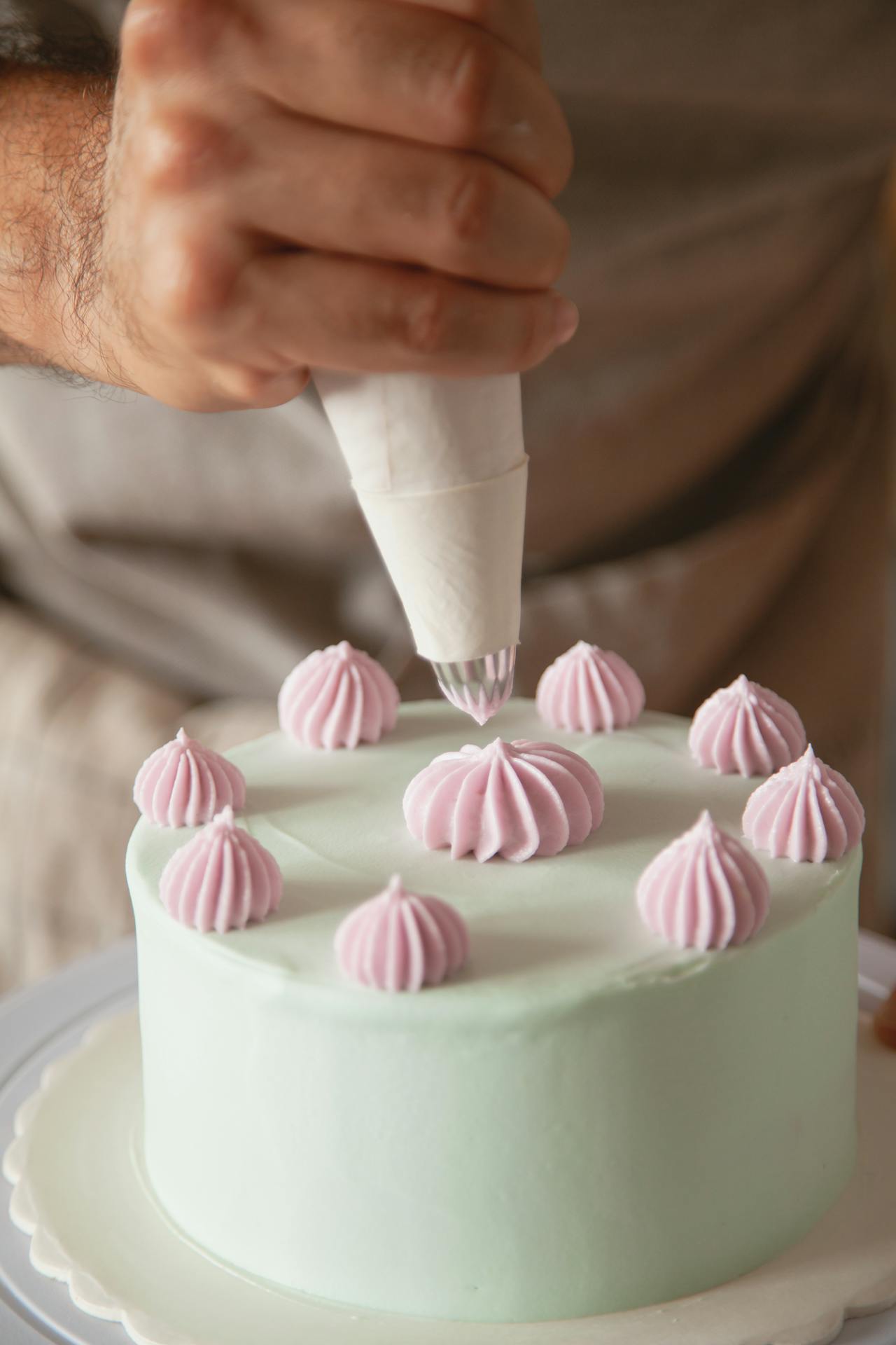 Un homme en train de décorer un gâteau | Source : Pexels