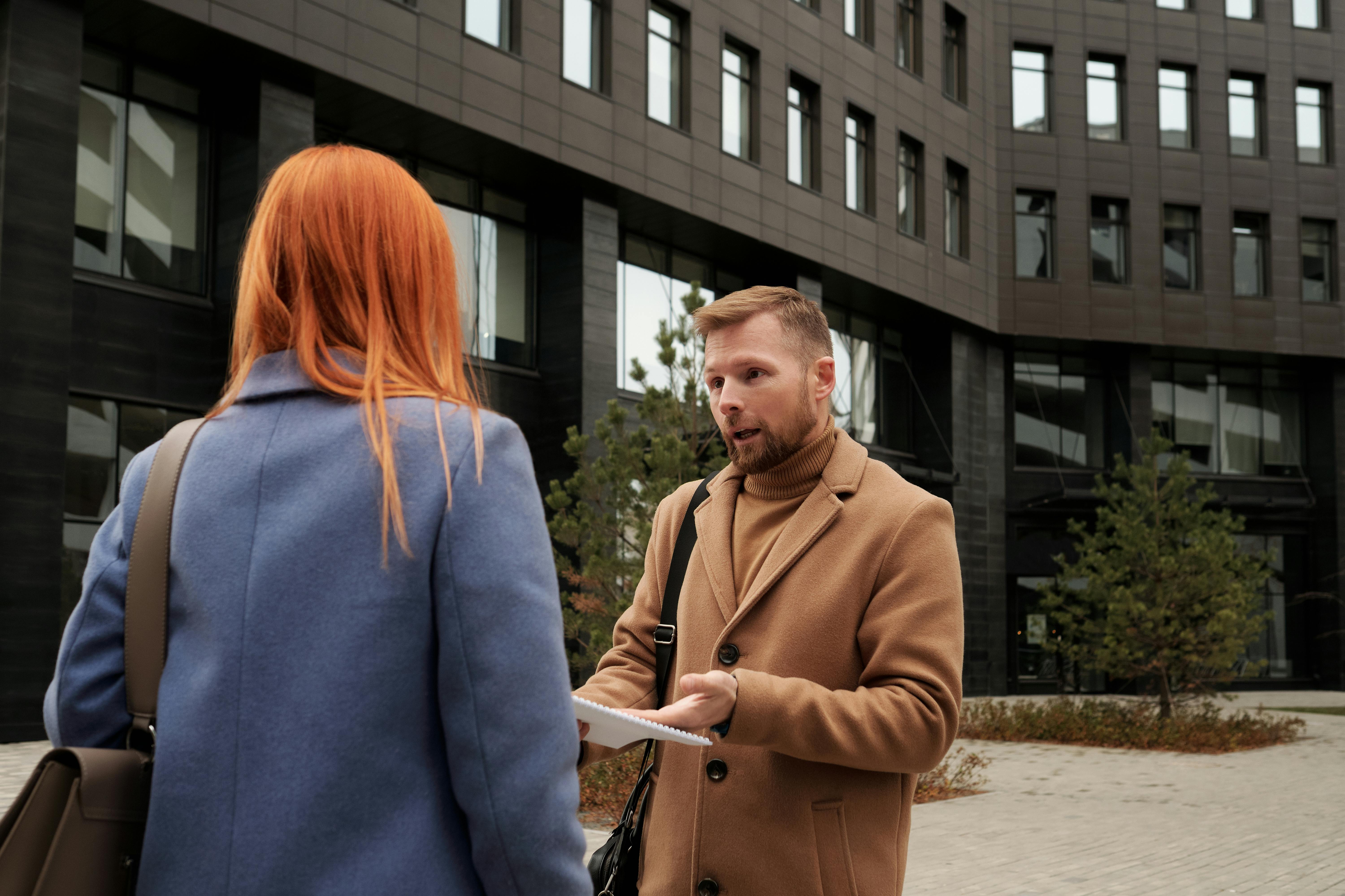 Un homme et une femme ayant une discussion sérieuse à l'extérieur d'un bâtiment | Source : Pexels