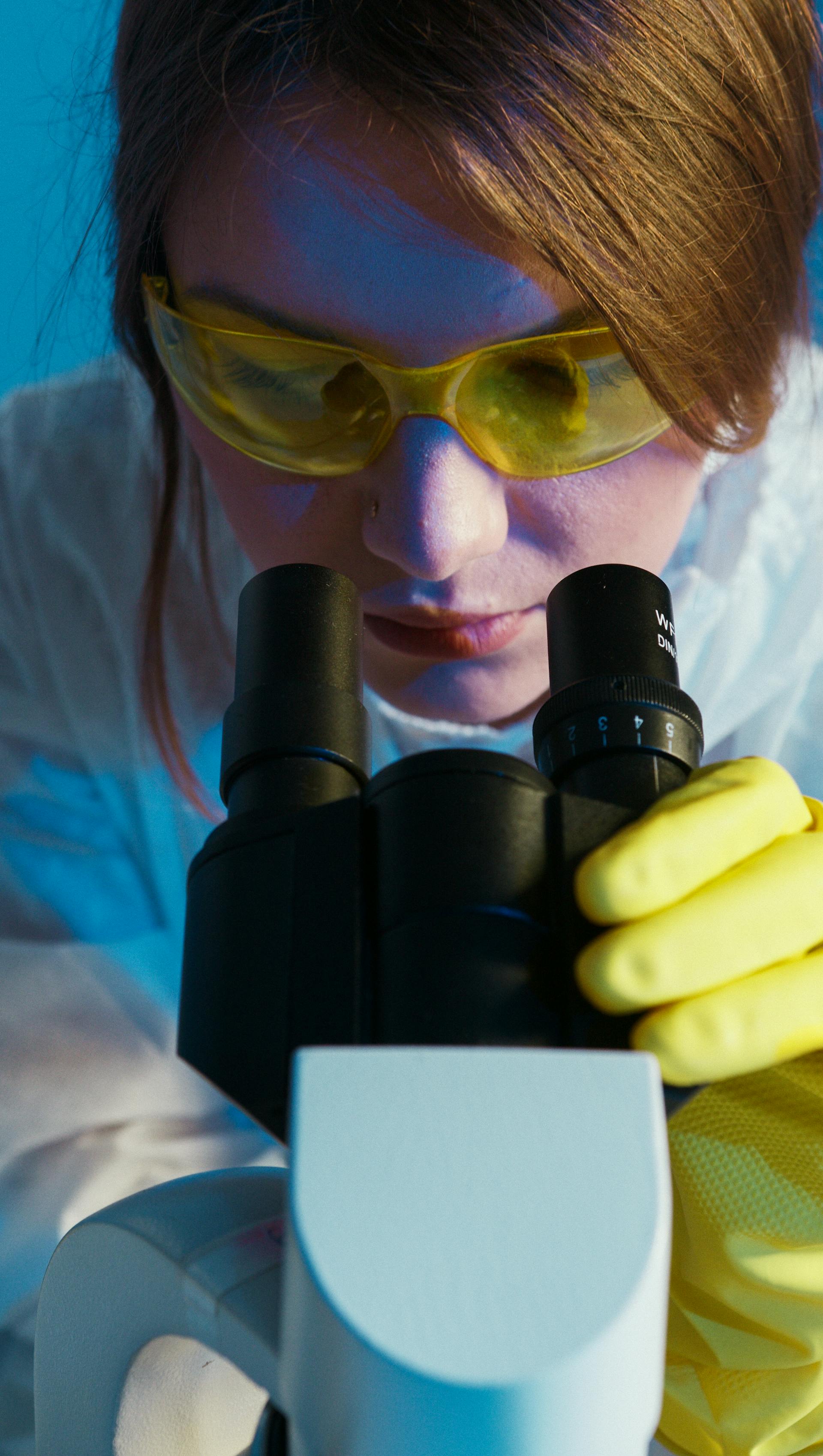 Une femme qui regarde à travers un microscope | Source : Pexels