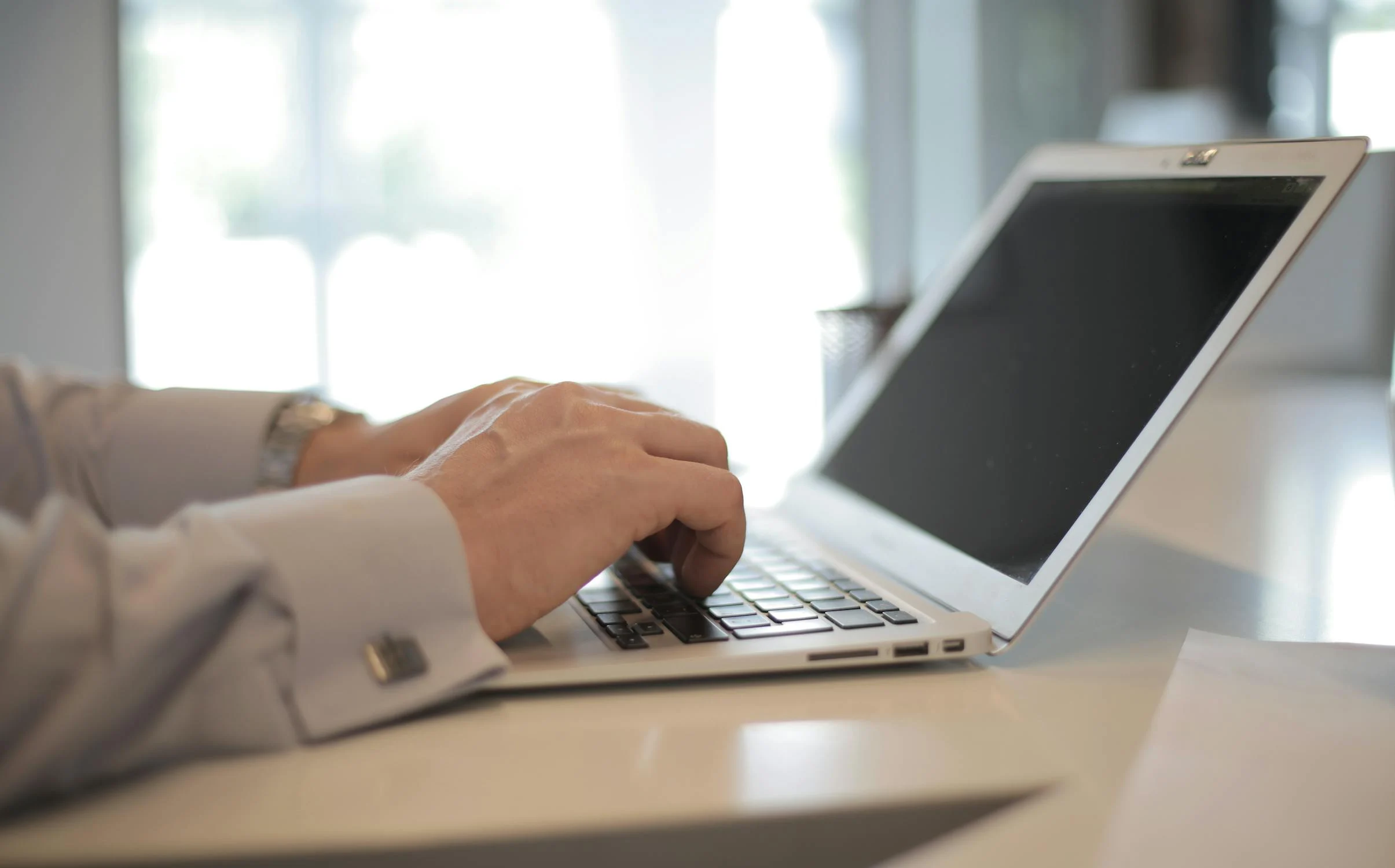Un homme tapant sur son ordinateur portable | Source : Pexels