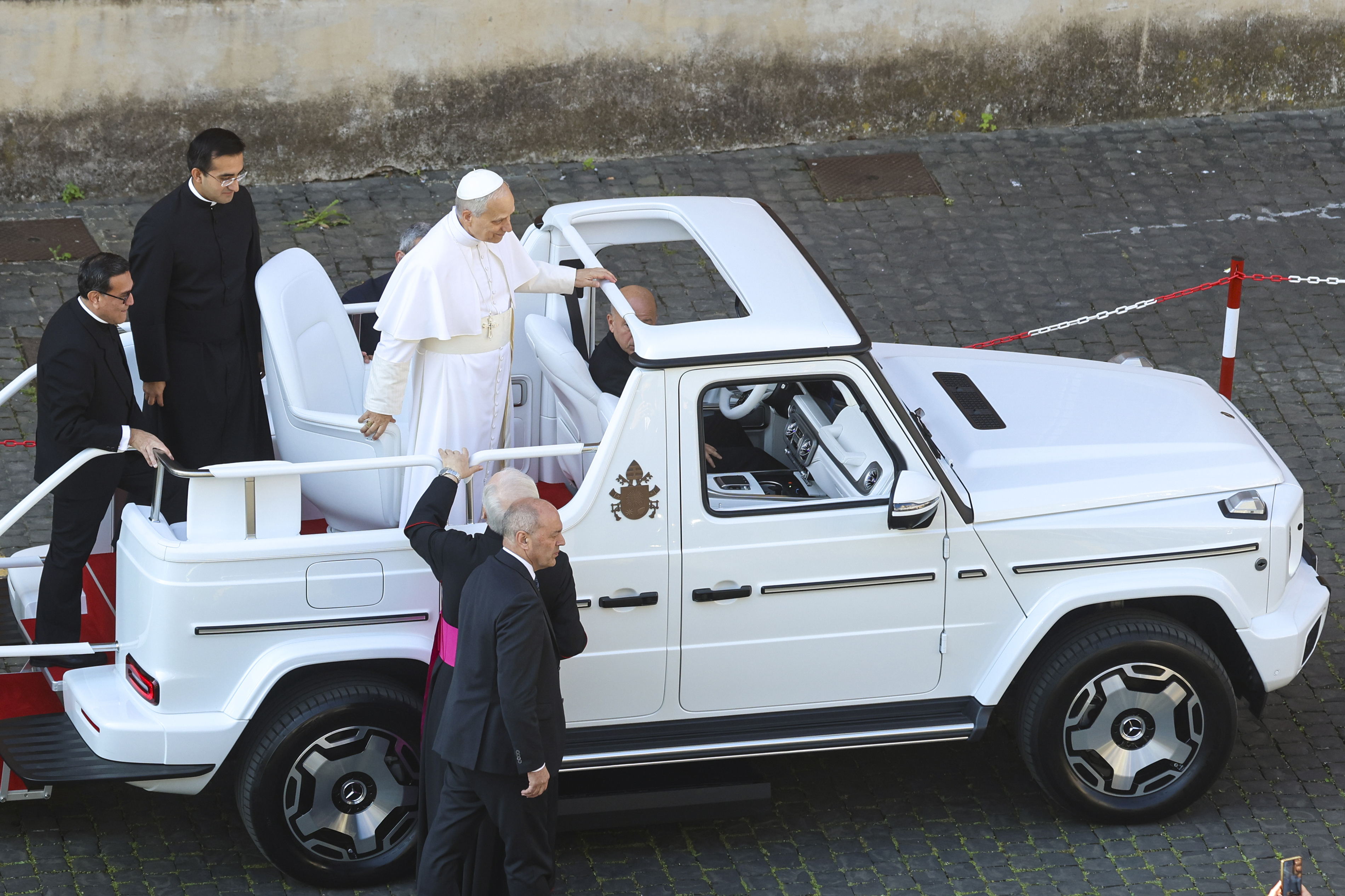 Le pape Léon XIV grimpant dans la papamobile avant d'entrer sur la place Saint-Pierre, le 18 mai 2025. | Source : Getty Images