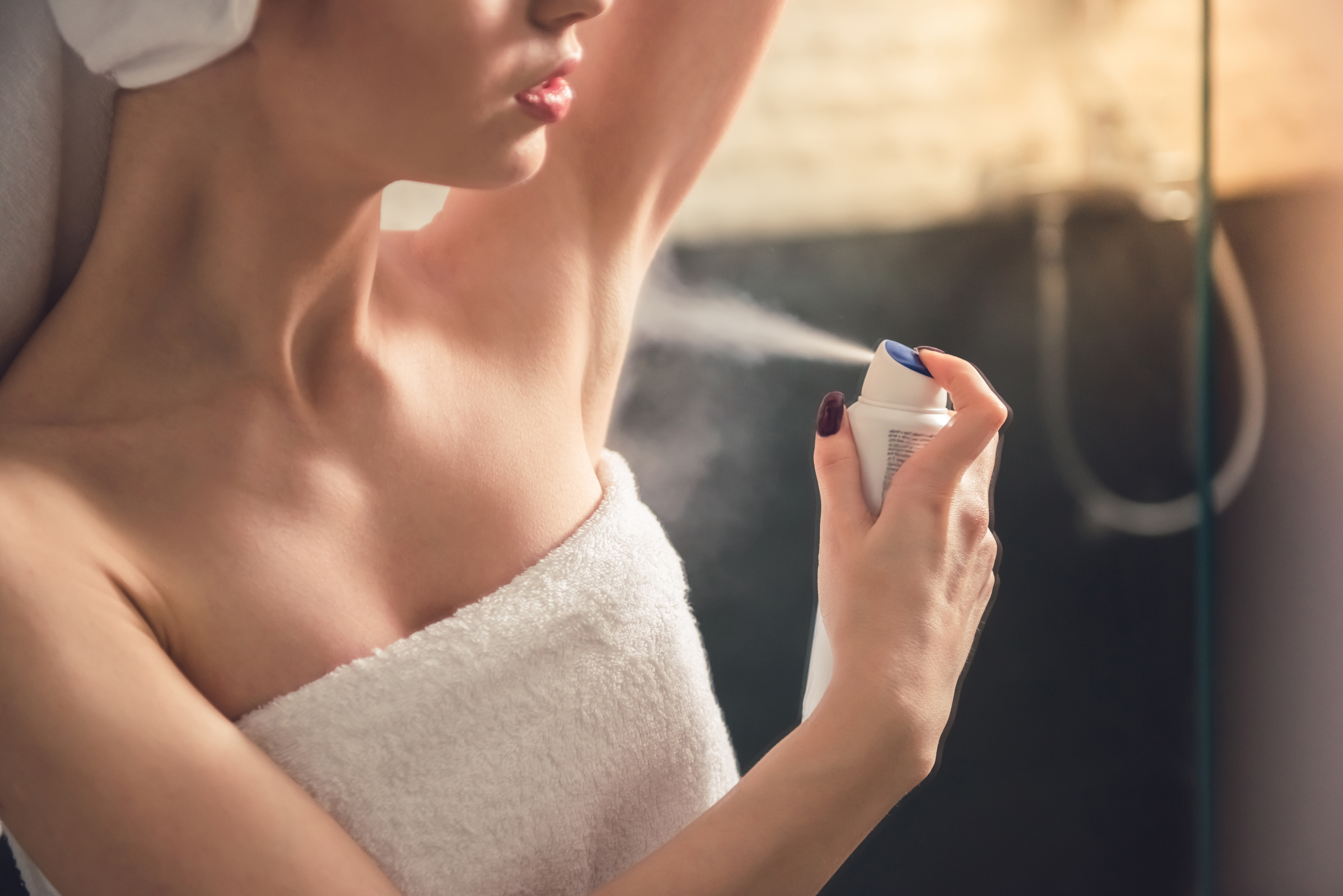 Femme vaporisant du déodorant sur ses aisselles | Source : Shutterstock