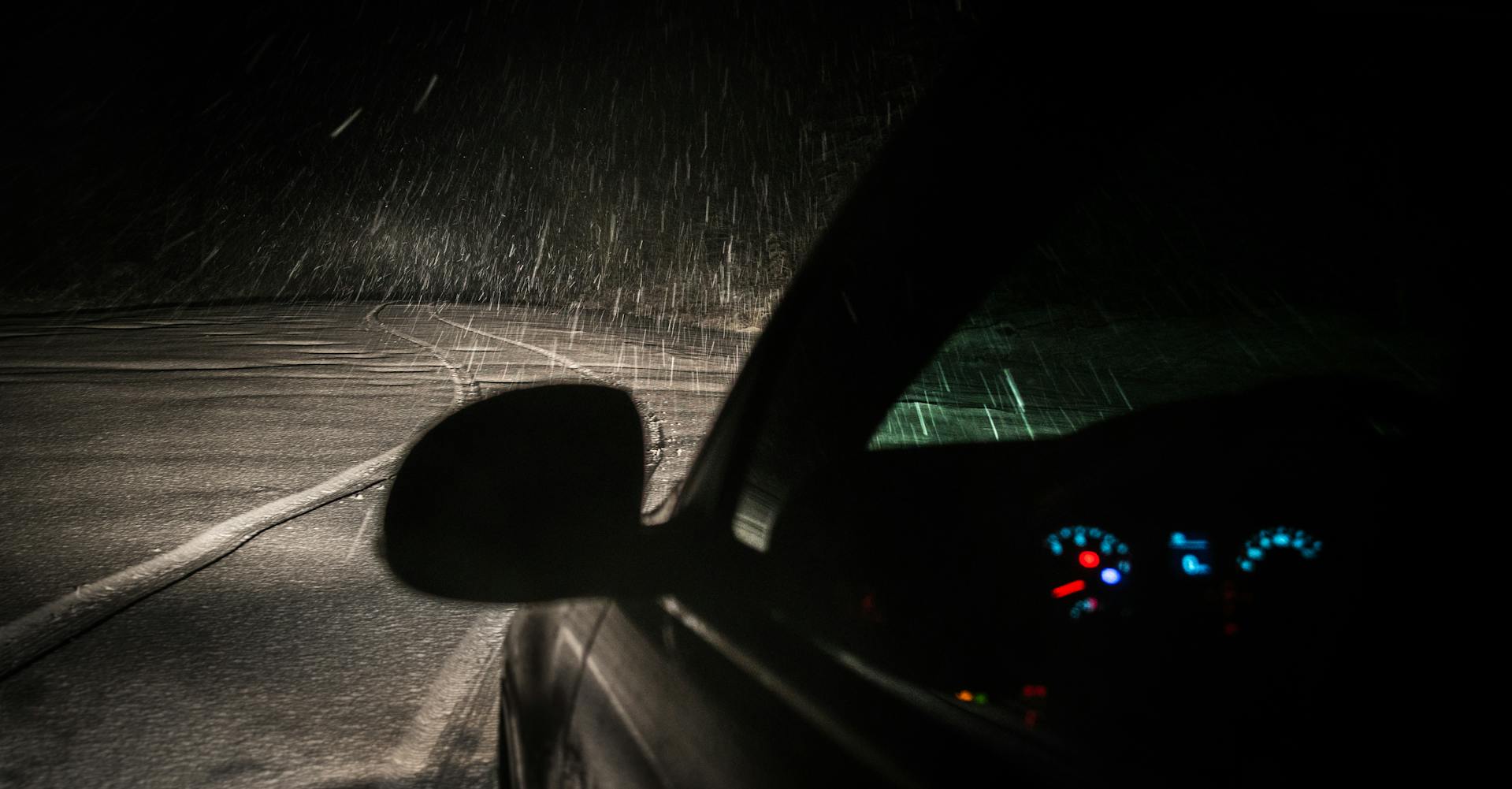 Une voiture sur une route vide par une nuit pluvieuse | Source : Pexels