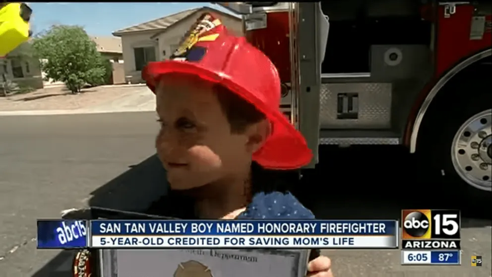 Le service d'incendie de Rural Metro honore Salvatore en lui remettant une chemise, un écusson, un casque et un certificat de pompier honoraire. | Photo : Youtube.com/abc15
