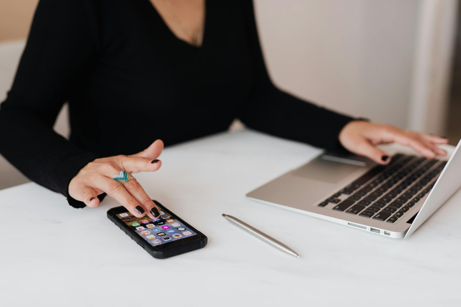 Une femme utilisant simultanément son ordinateur portable et son téléphone | Source : Pexels