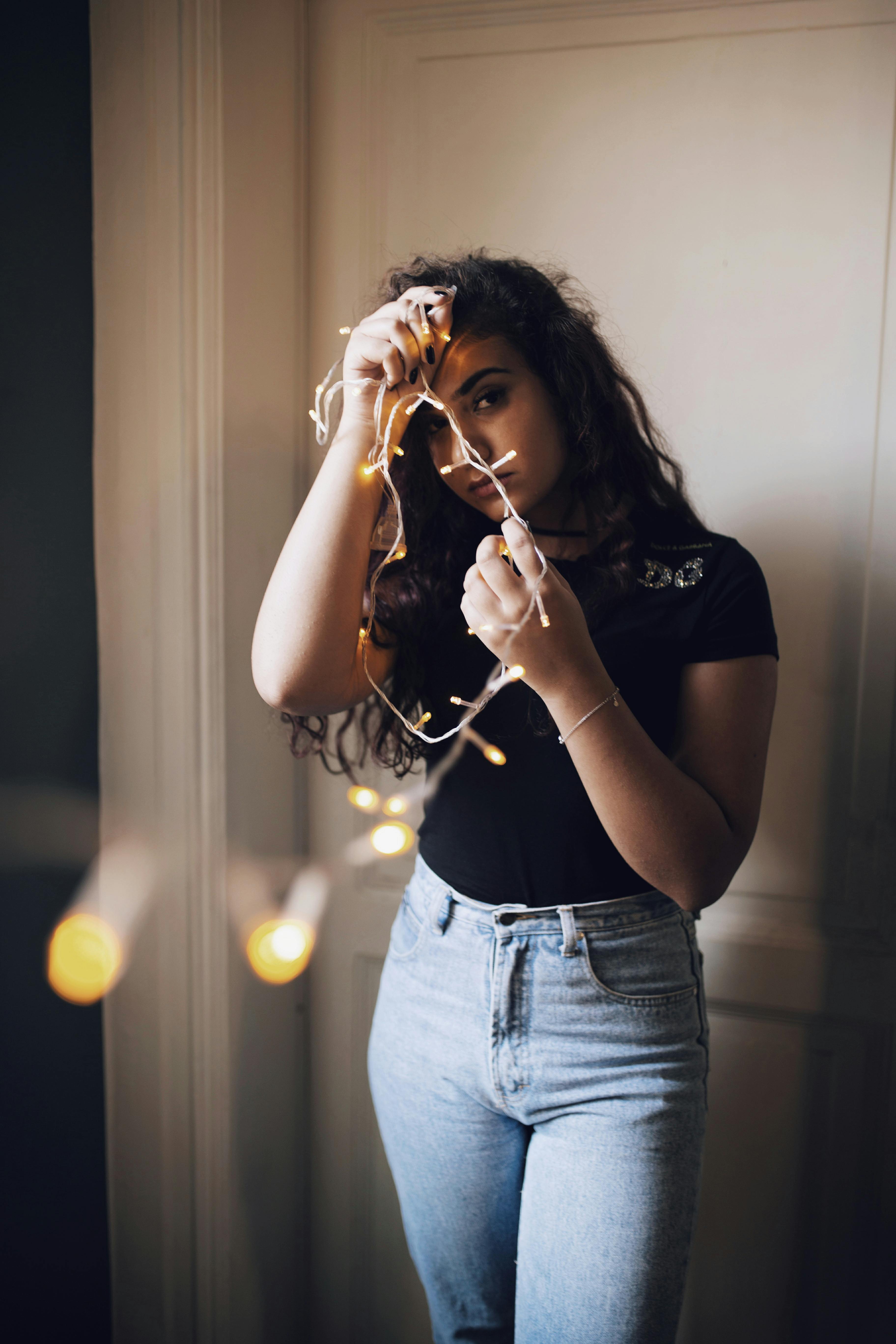 Woman holding a string of lights | Source: Pexels