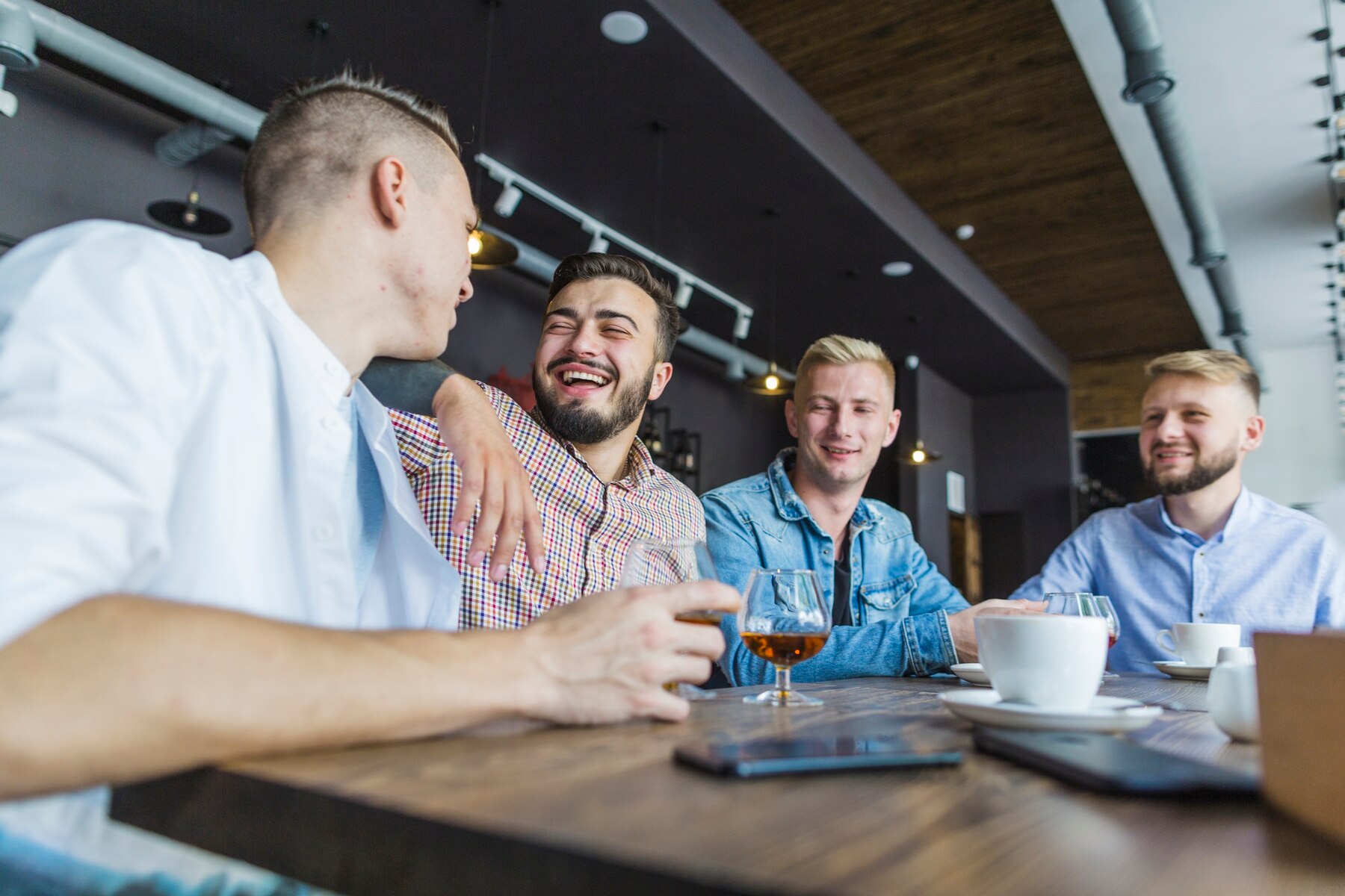 Des hommes qui rient dans un restaurant | Source : Pexels