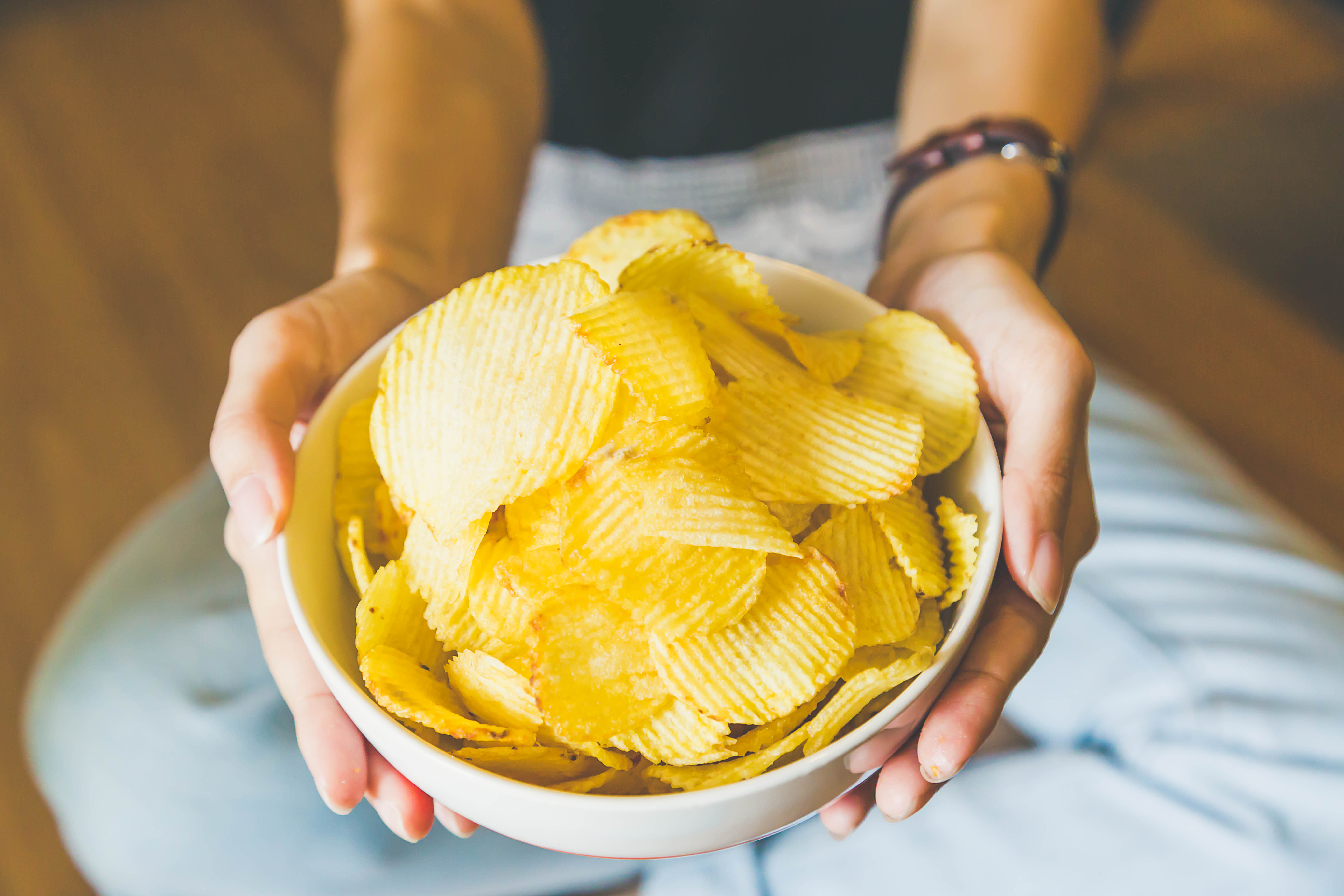 Une personne tenant un bol de chips | Source : Shutterstock