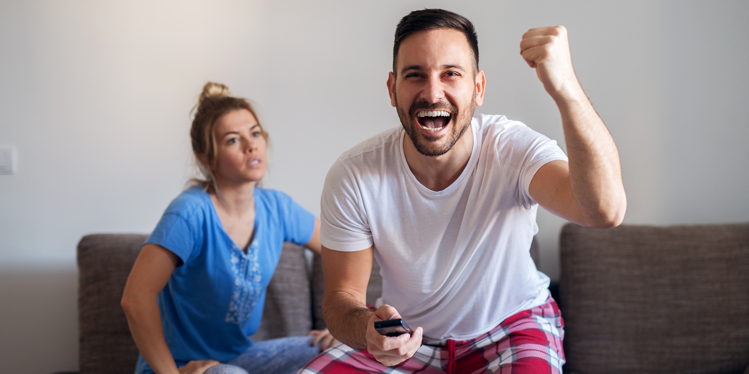 Une femme qui regarde son mari pendant qu'il regarde la télévision | Source : Shutterstock