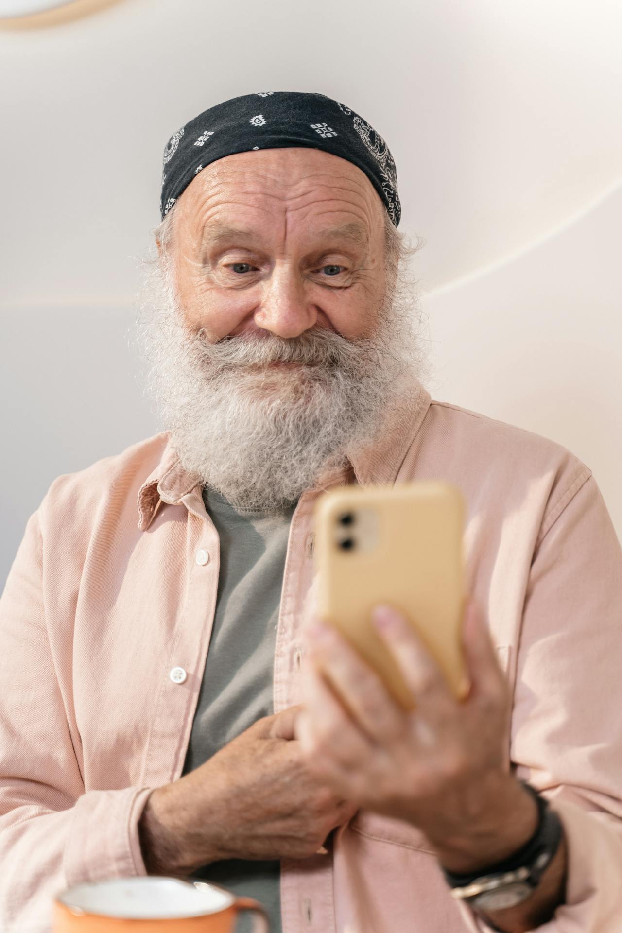 Un homme plus âgé qui regarde son téléphone et sourit | Source : Pexels