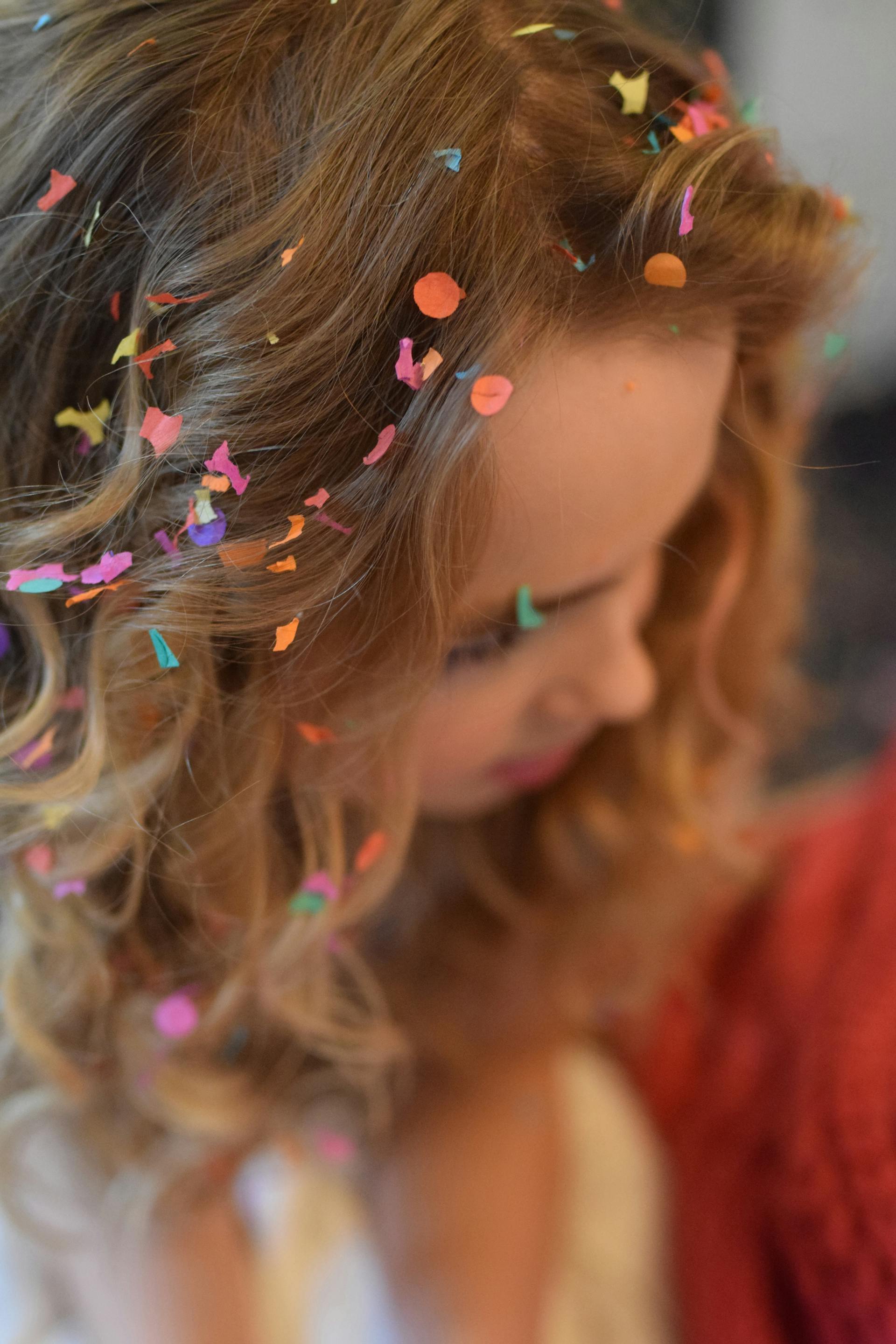 Une femme aux cheveux bruns avec des confettis dans les cheveux | Source : Pexels