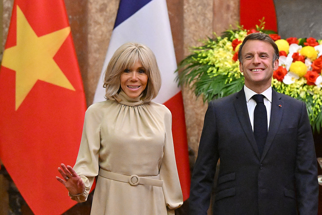 TOPSHOT - Le président français Emmanuel Macron et son épouse Brigitte Macron réagissent alors qu'ils posent pour des photos avec le président vietnamien Luong Cuong et son épouse Nguyen Thi Minh Nguyet lors d'une réunion au palais présidentiel à Hanoi le 26 mai 2025. (Photo by NHAC NGUYEN / POOL / AFP) (Photo by NHAC NGUYEN/POOL/AFP via Getty Images)