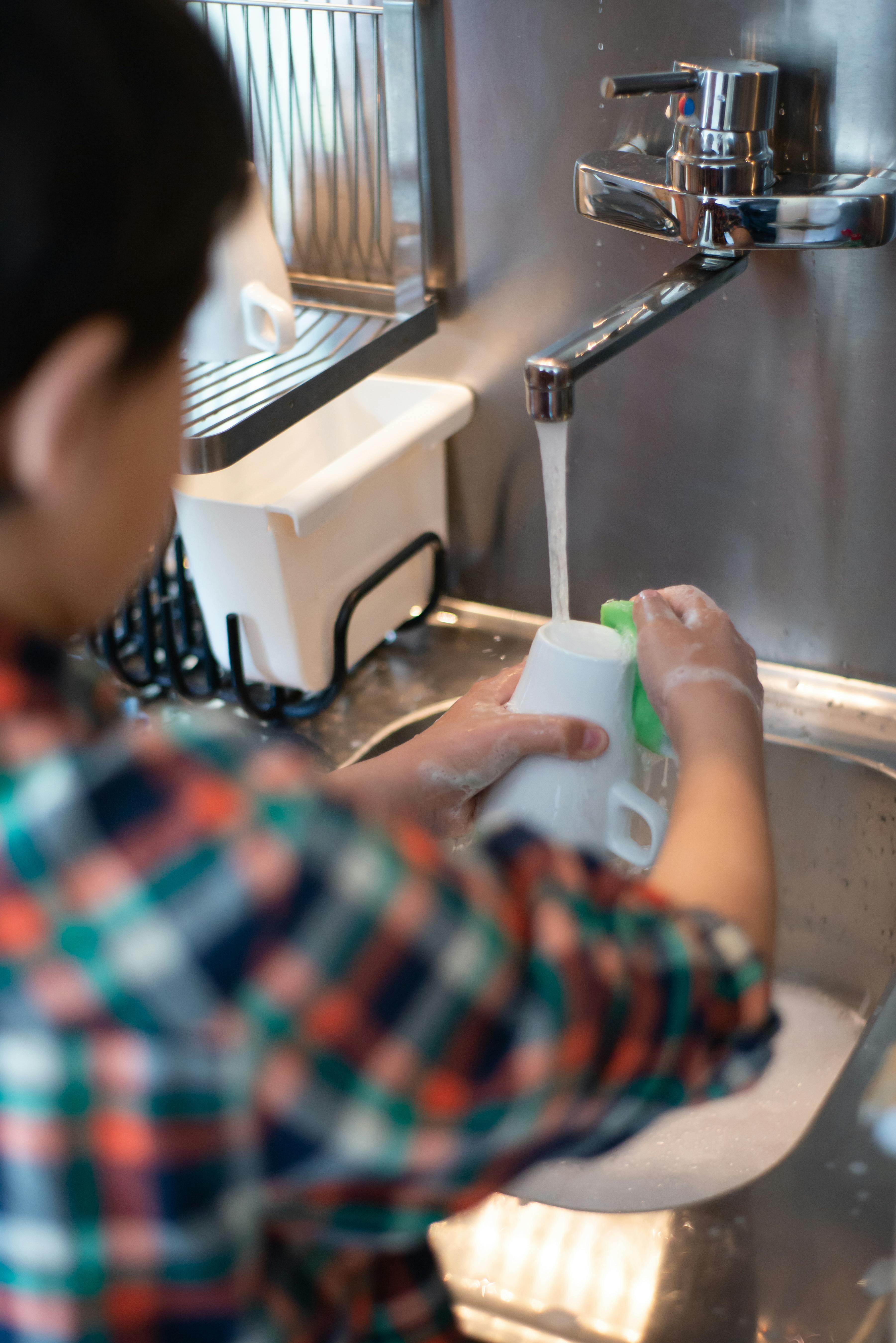 Un enfant lave une tasse | Source : Pexels