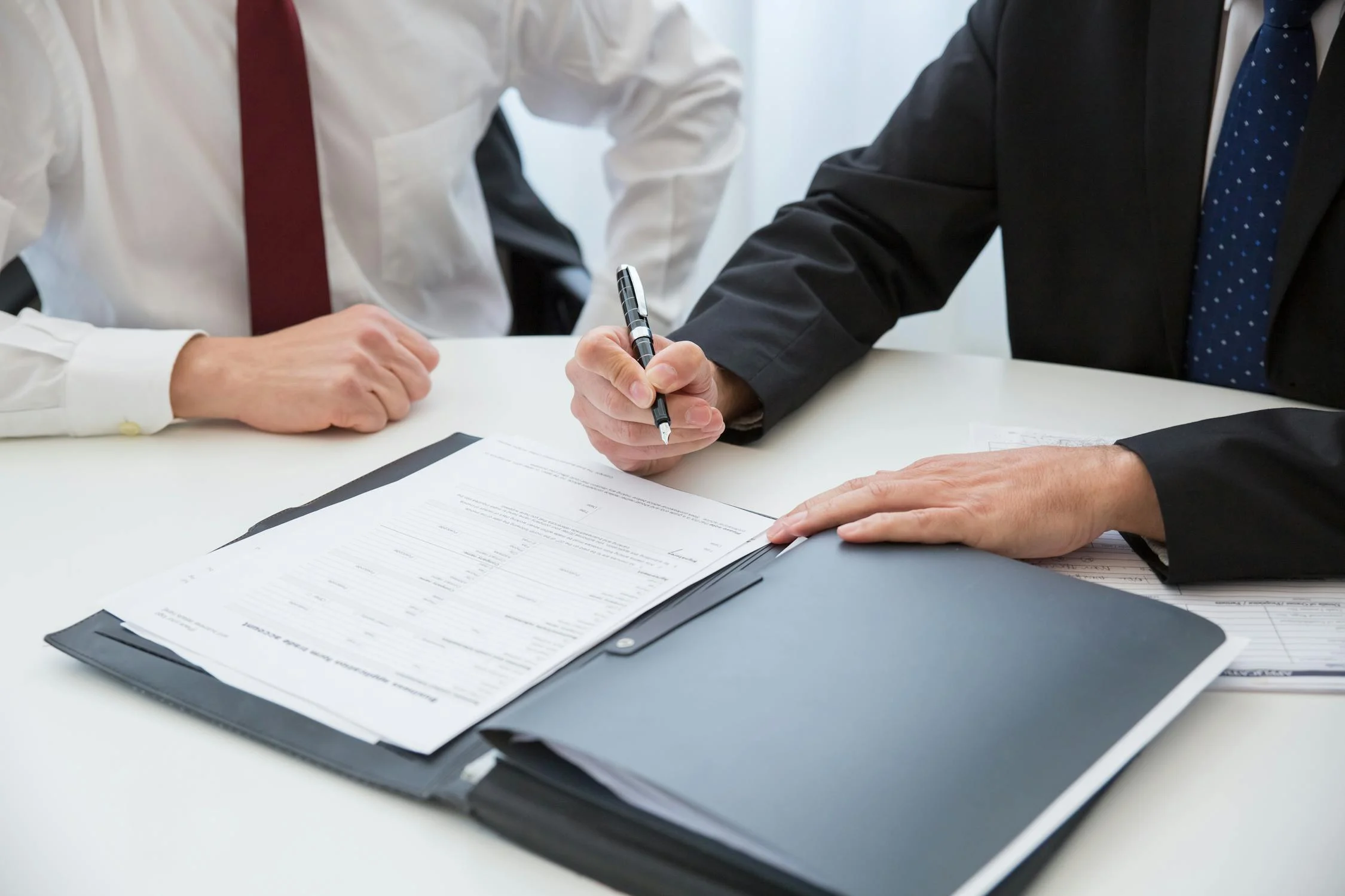 Un homme signant des documents | Source : Pexels