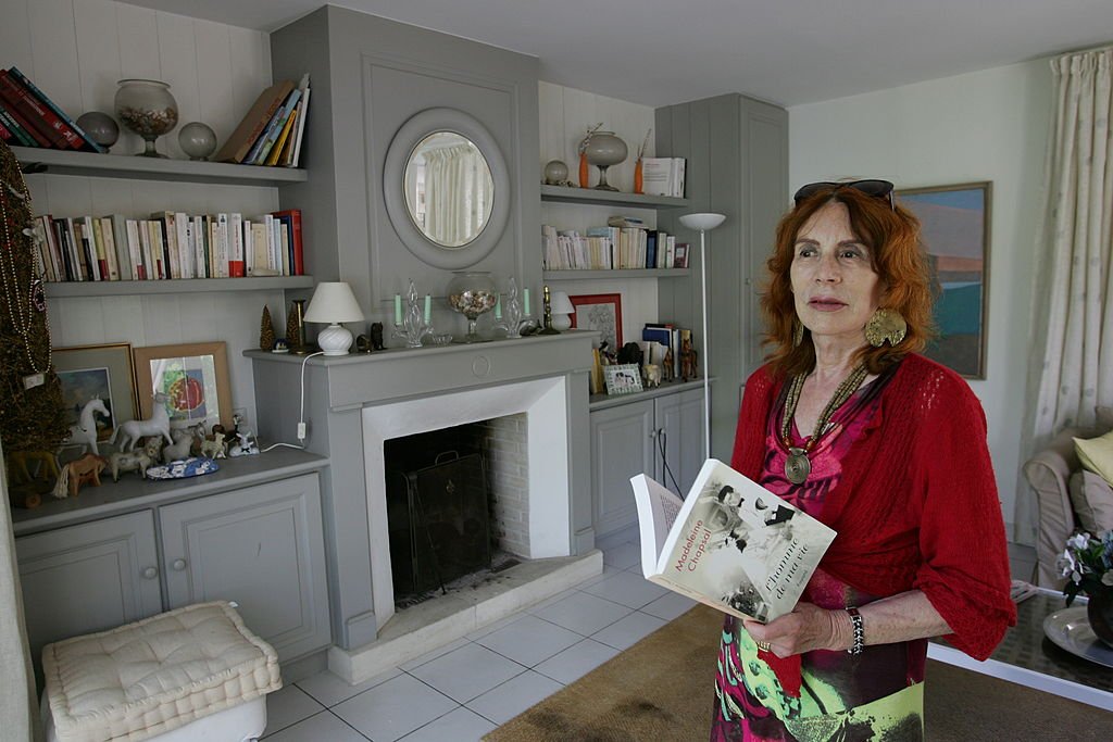 Madeleine Chapsal tenant un livre chez elle | Photo : Getty Images