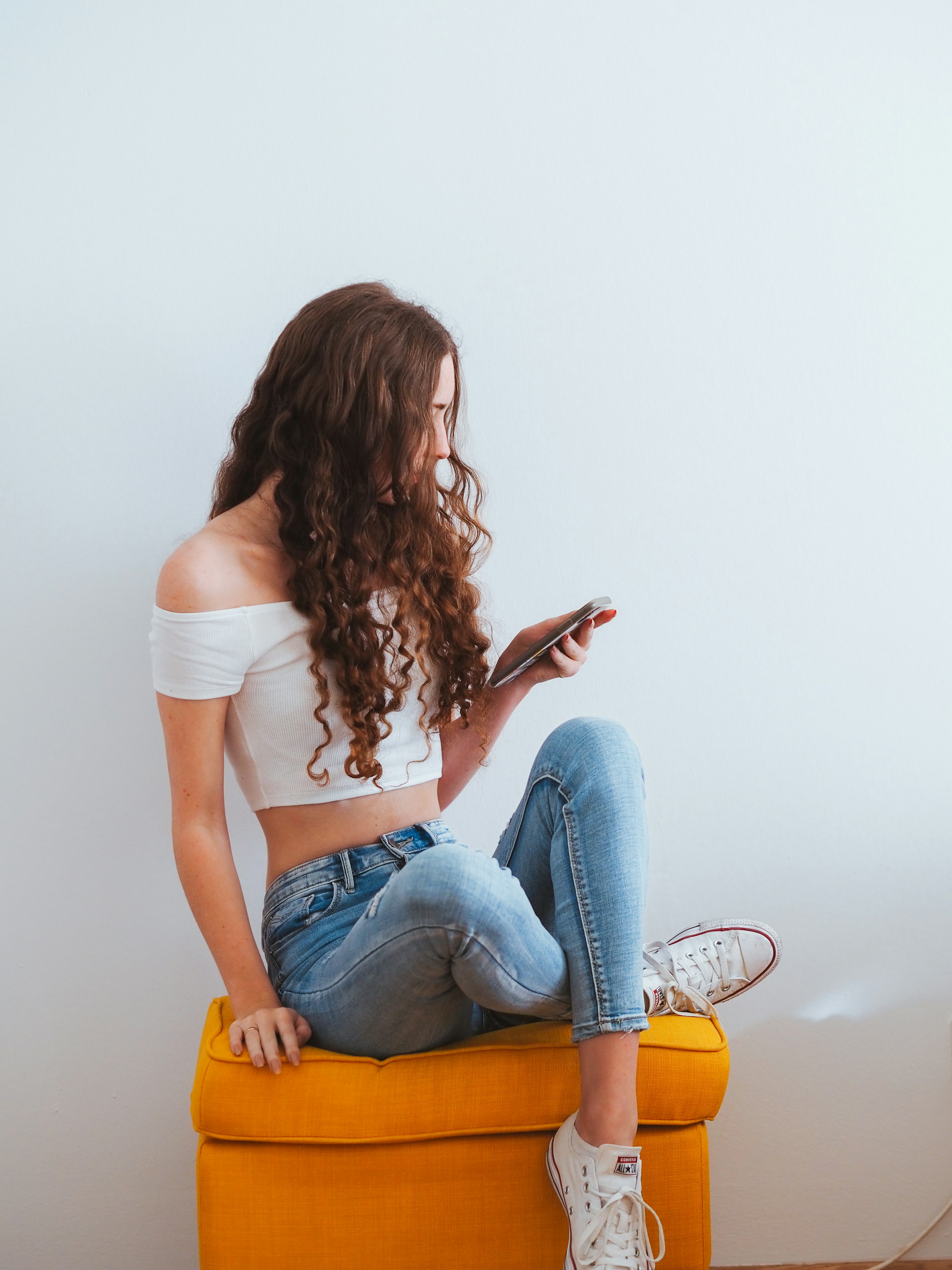 Une jeune femme tenant son téléphone | Source : Unsplash