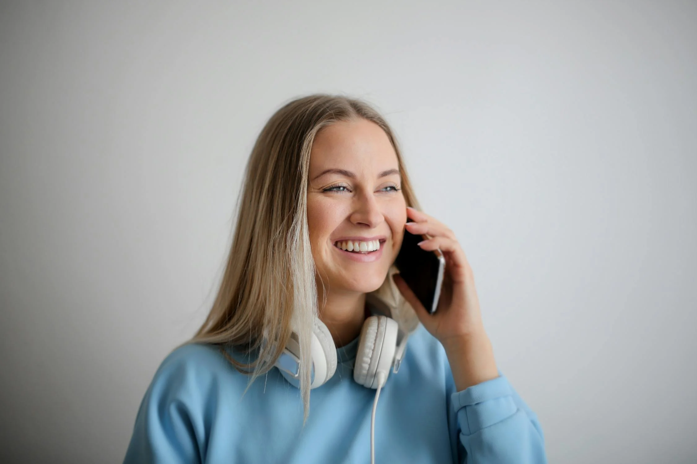 Une femme souriante qui parle au téléphone | Source : Pexels