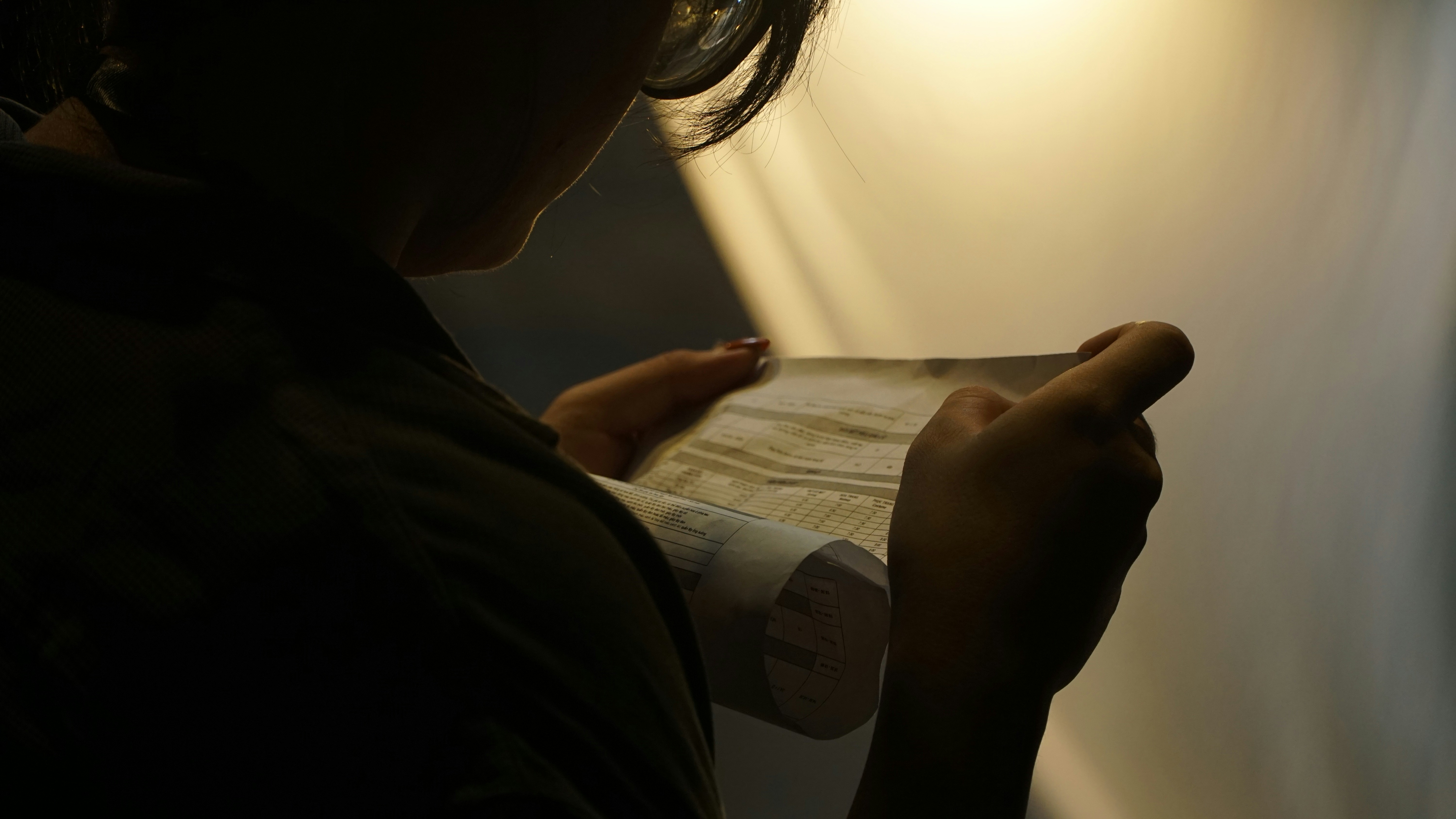 Une femme examine minutieusement un document | Source : Unsplash