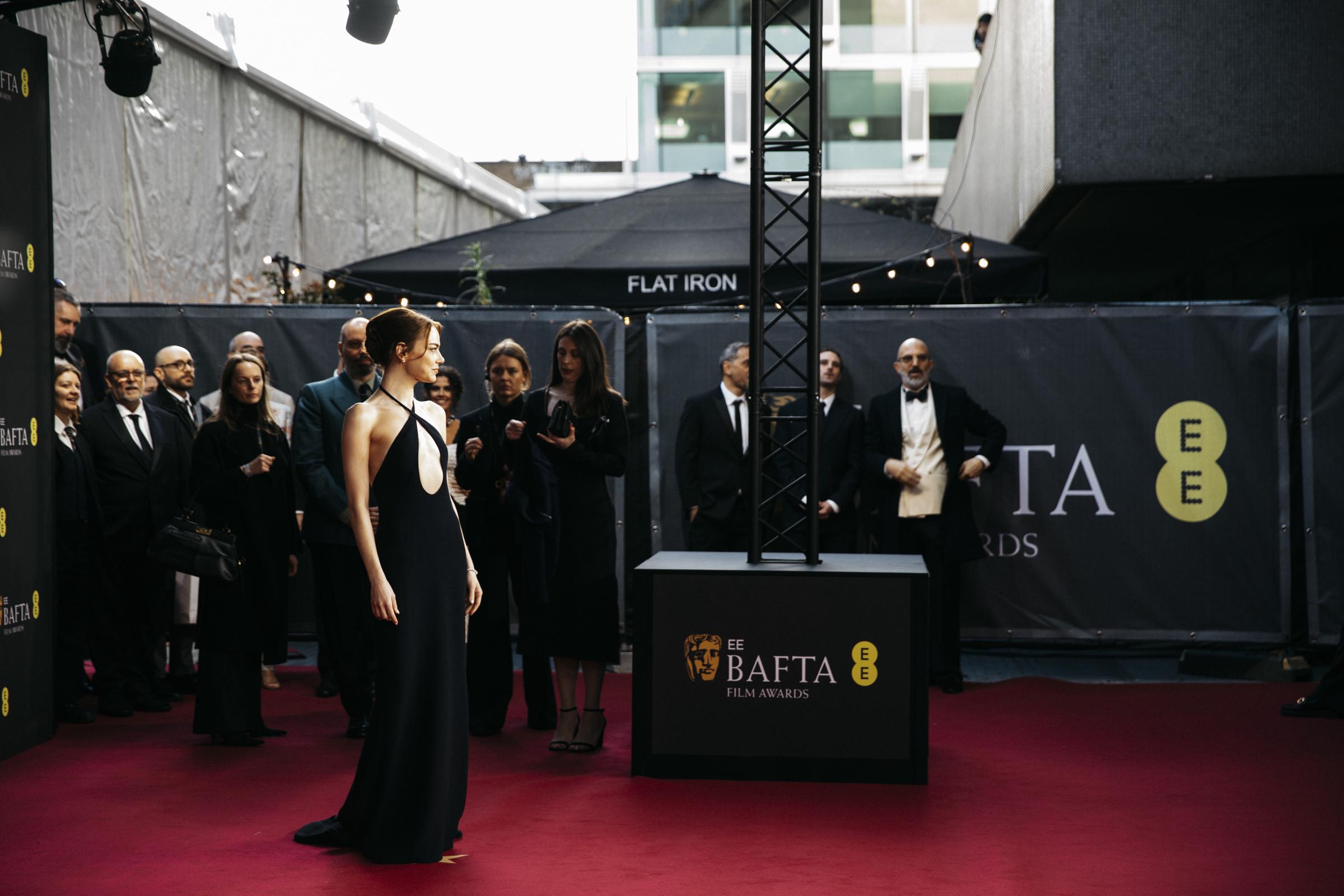 Emma Stone pose avec assurance à l'arrivée, sa robe à découpe ovale spectaculaire et sa silhouette fluide attirant immédiatement l'attention des photographes et des invités qui l'observent depuis les coulisses.