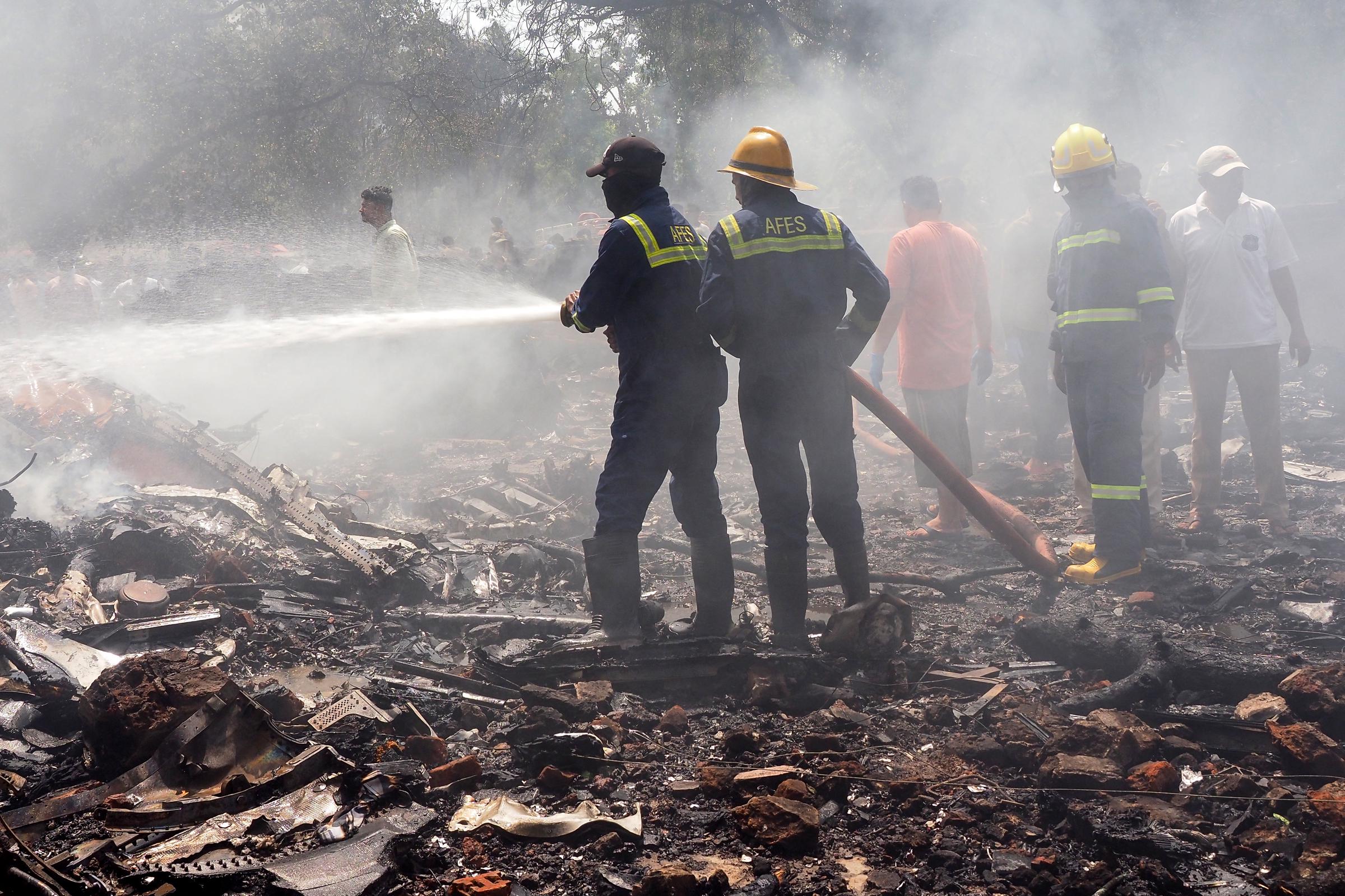 Des pompiers travaillent sur le site où le vol 171 d'Air India s'est écrasé dans une zone résidentielle près de l'aéroport d'Ahmedabad, le 12 juin 2025. L'avion de ligne à destination de Londres s'est écrasé le 12 juin, dans l'ouest de l'Inde, avec à bord 242 personnes I Source : Getty Images