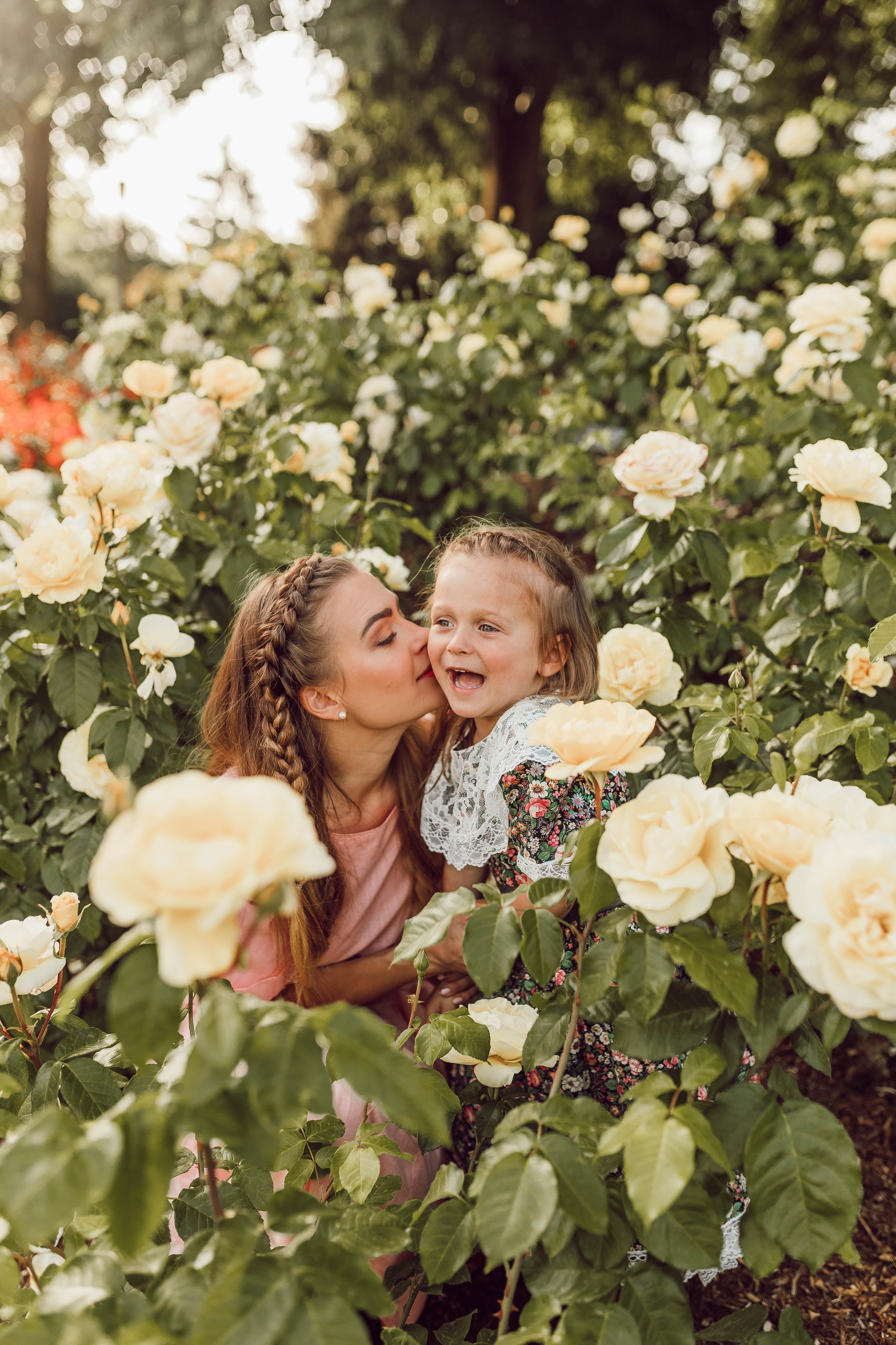 Une mère embrassant sa fille dans un jardin | Source : Unsplash