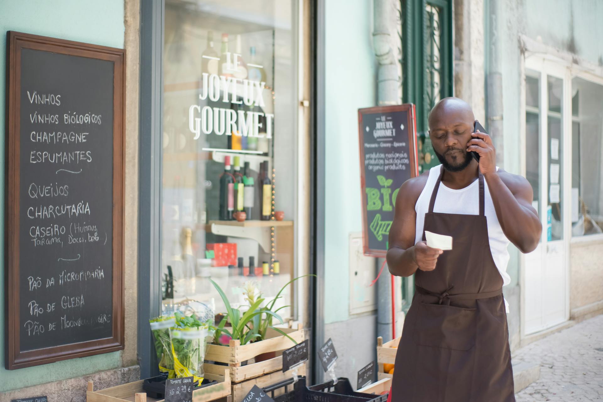 Un homme tenant une note tout en passant un appel téléphonique | Source : Pexels