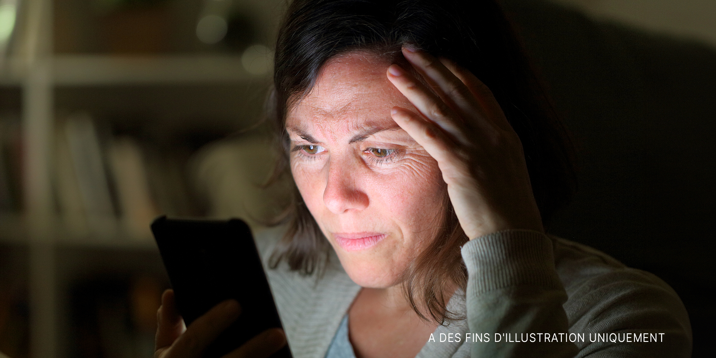 Une femme inquiète regarde son téléphone | Source : Shutterstock