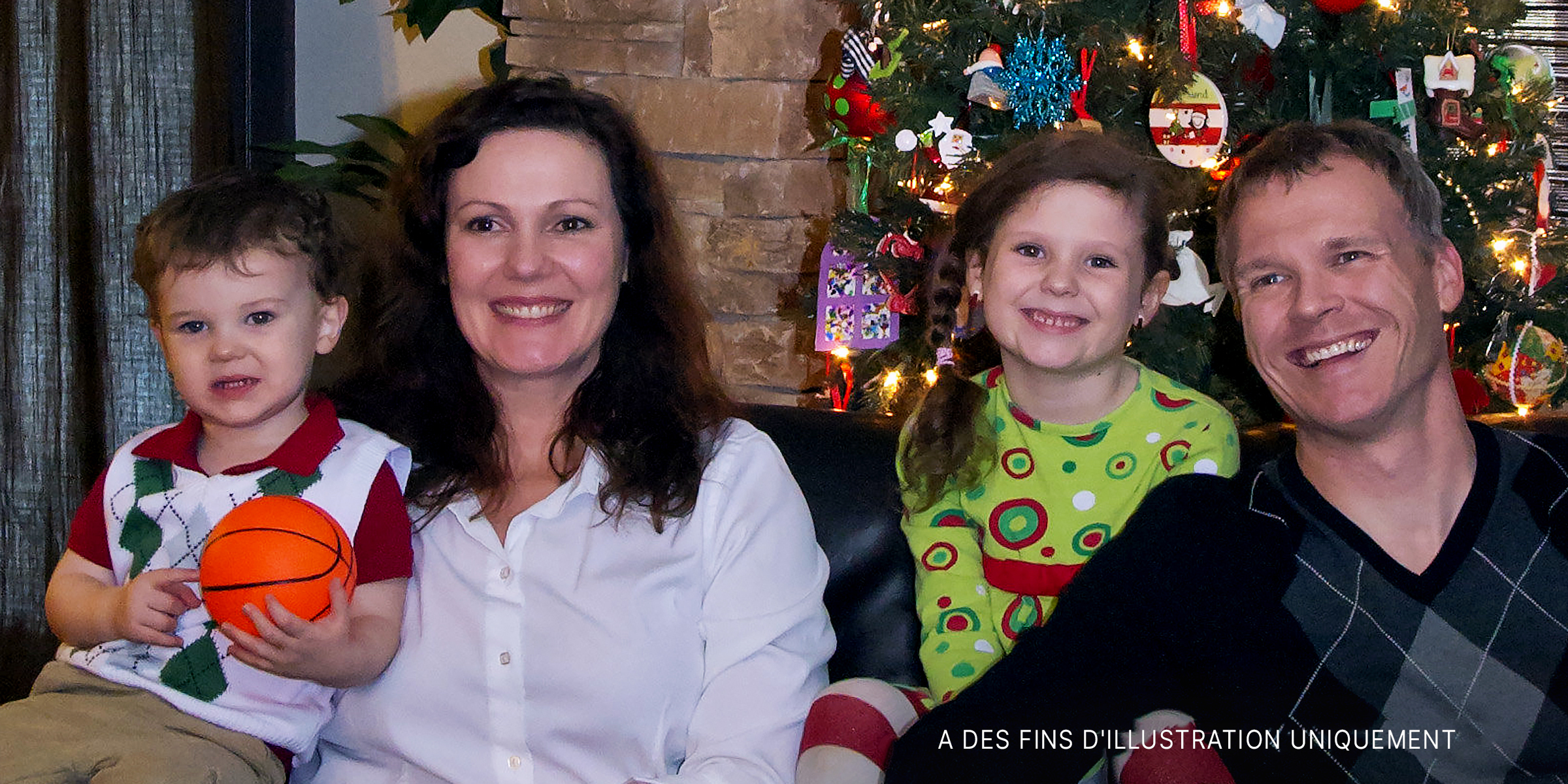 Une famille heureuse de quatre personnes posant ensemble le jour de Noël | Source : Flickr.com/GordonCC BY-SA 2.0
