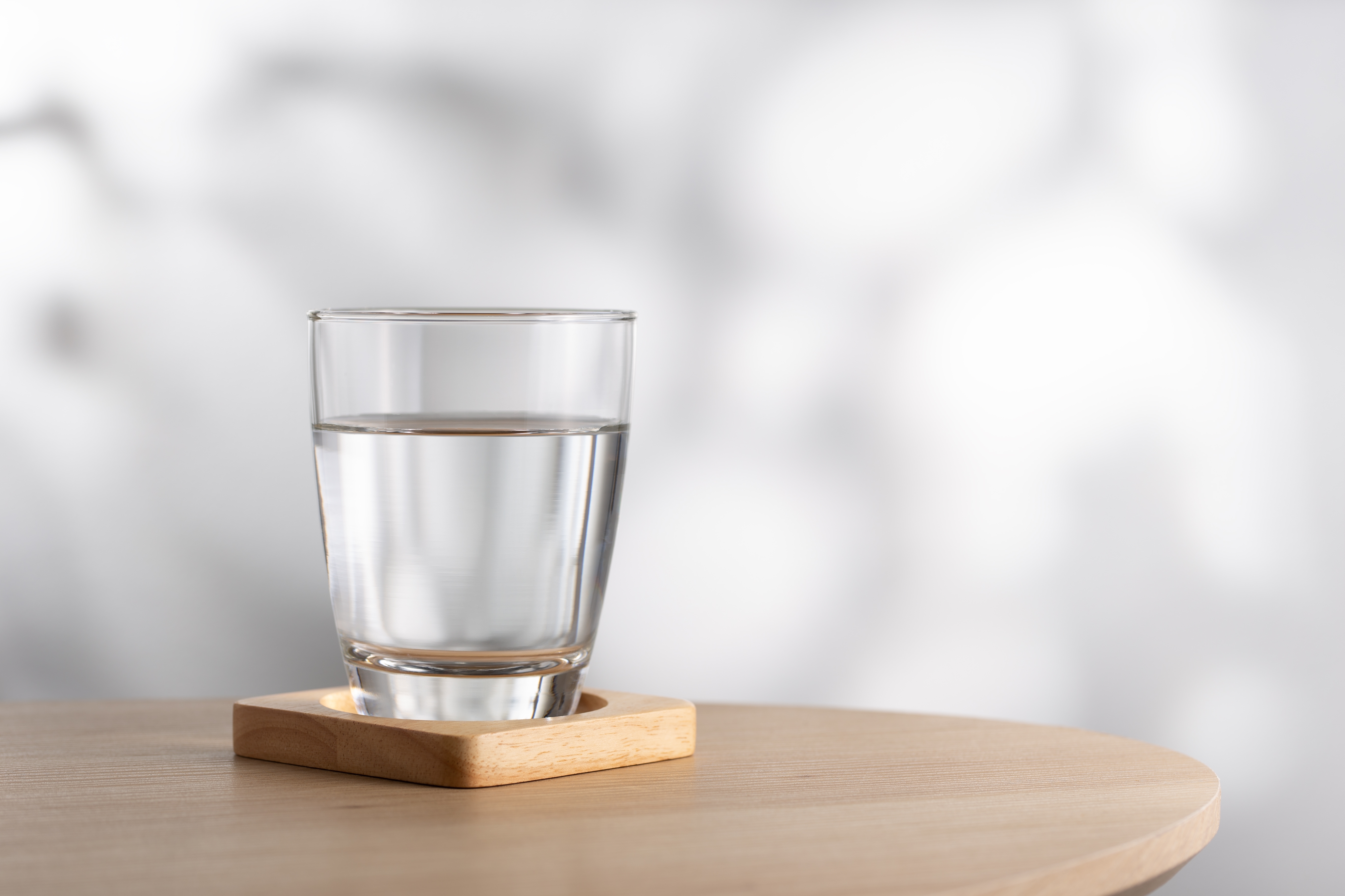 Un verre d'eau sur une table en bois | Source : Shutterstock