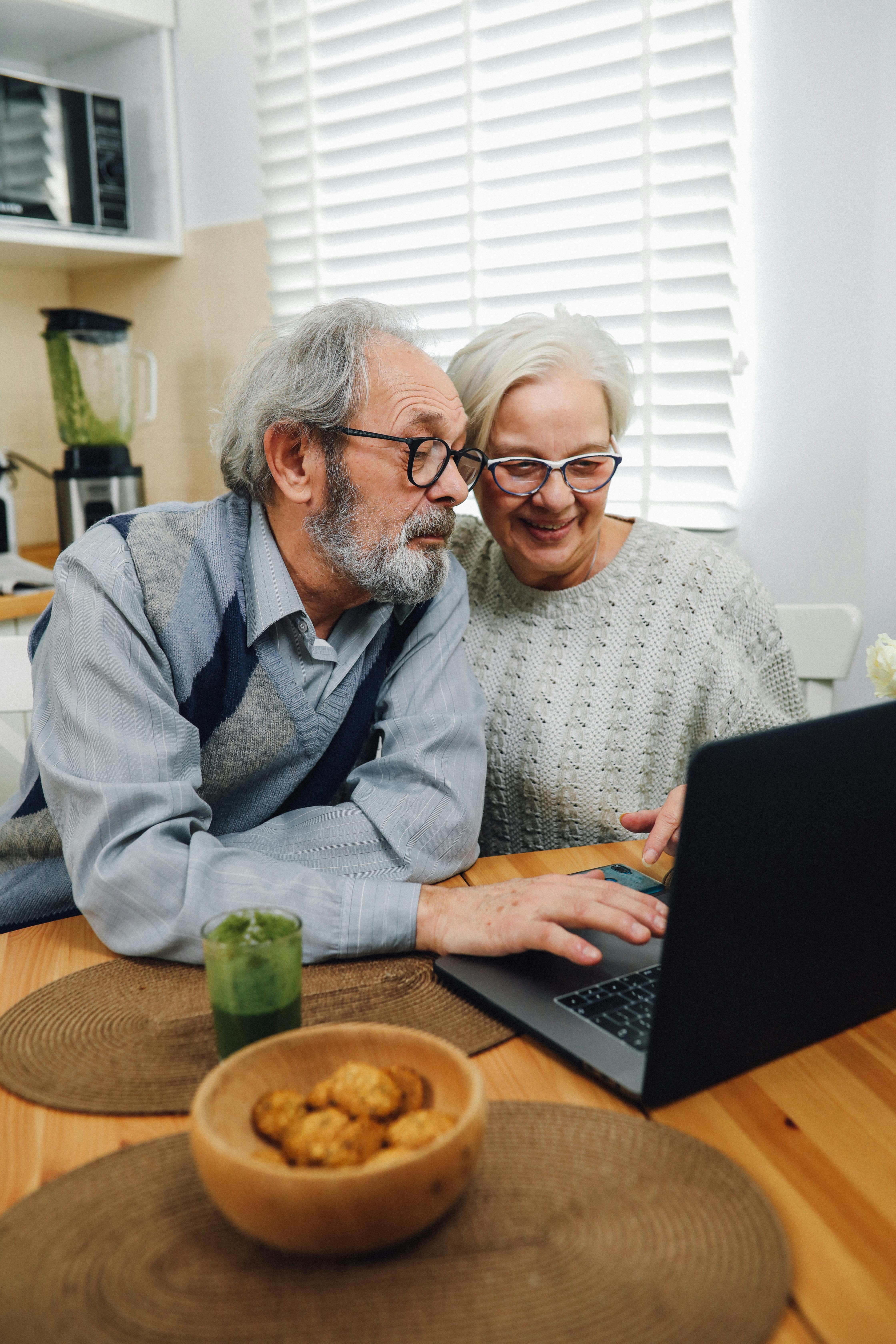 Un couple de personnes âgées utilisant ensemble un ordinateur portable | Source : Pexels