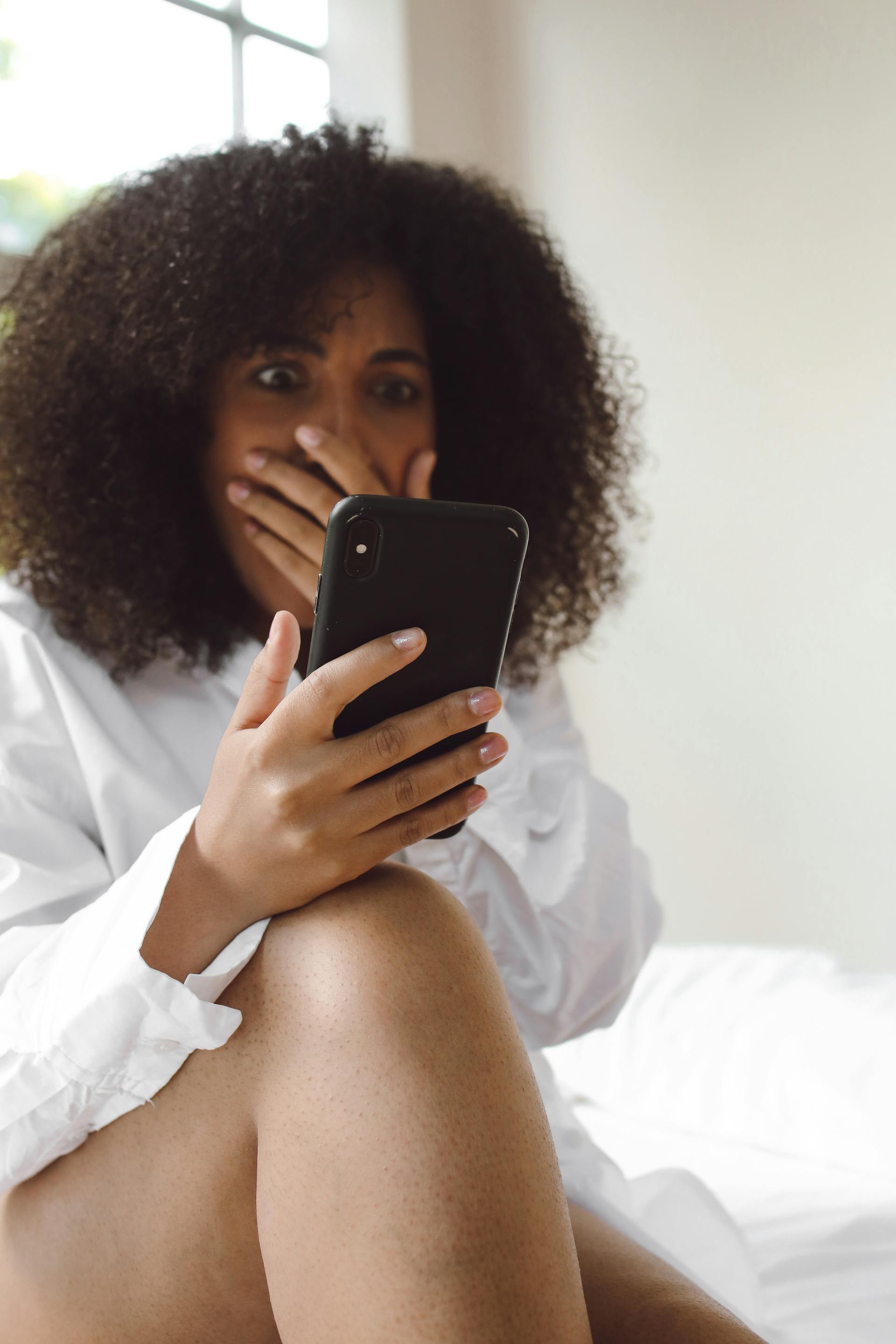 Une femme choquée qui regarde un téléphone | Source : Pexels