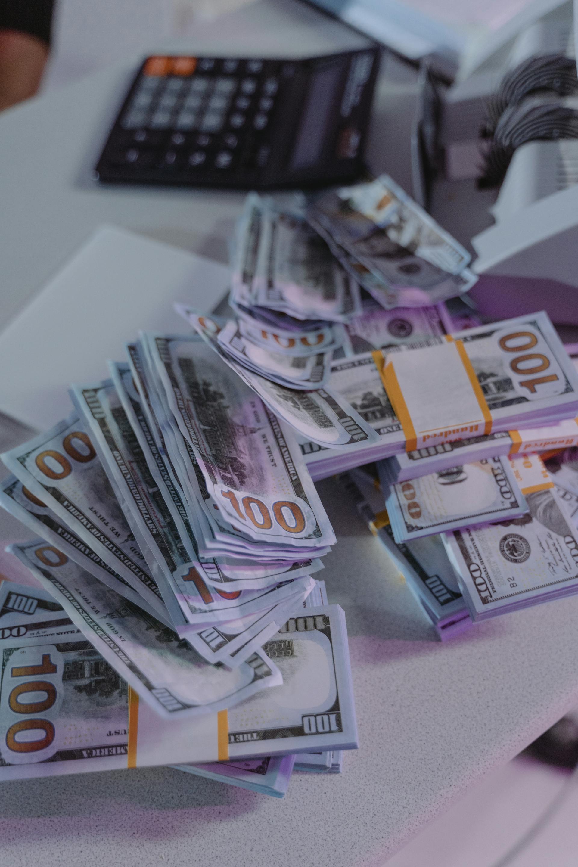 Des liasses de billets de 100 dollars posés sur une table | Source : Pexels