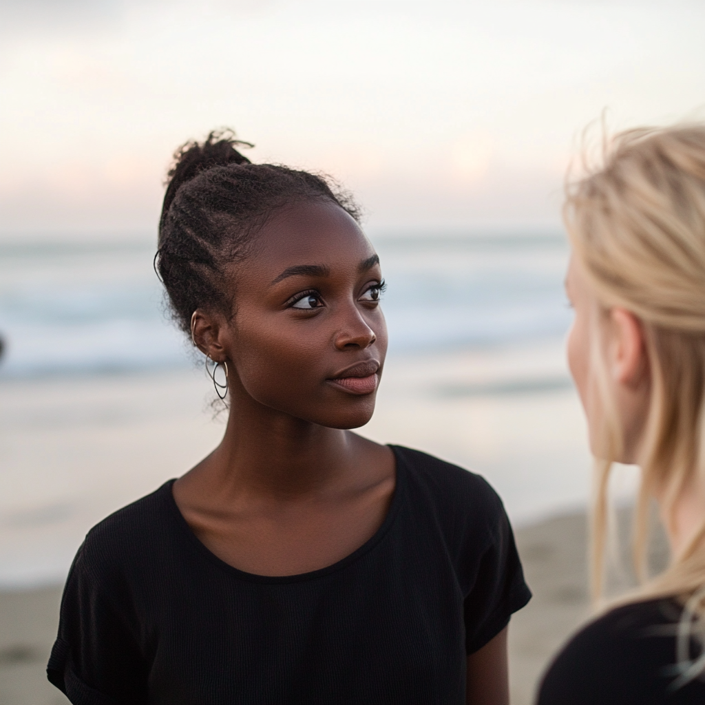 Deux femmes discutent à la plage | Source : Midjourney