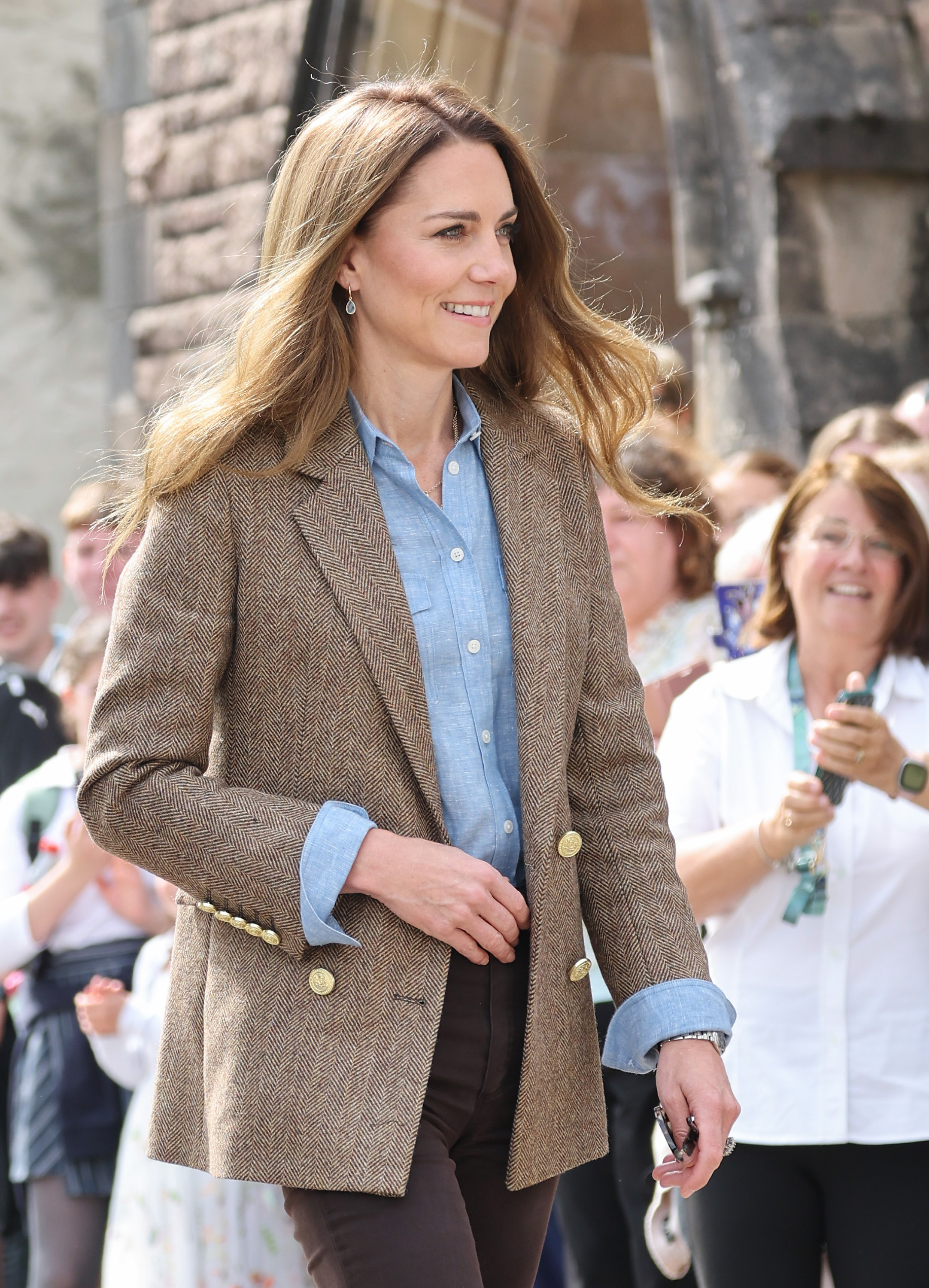 Catherine traverse Tobermory avec un doux sourire, entourée de sympathisants. Son apparence - notamment son blazer en tweed marron et sa chemise bleue - a attiré beaucoup d'attention pendant la visite royale.