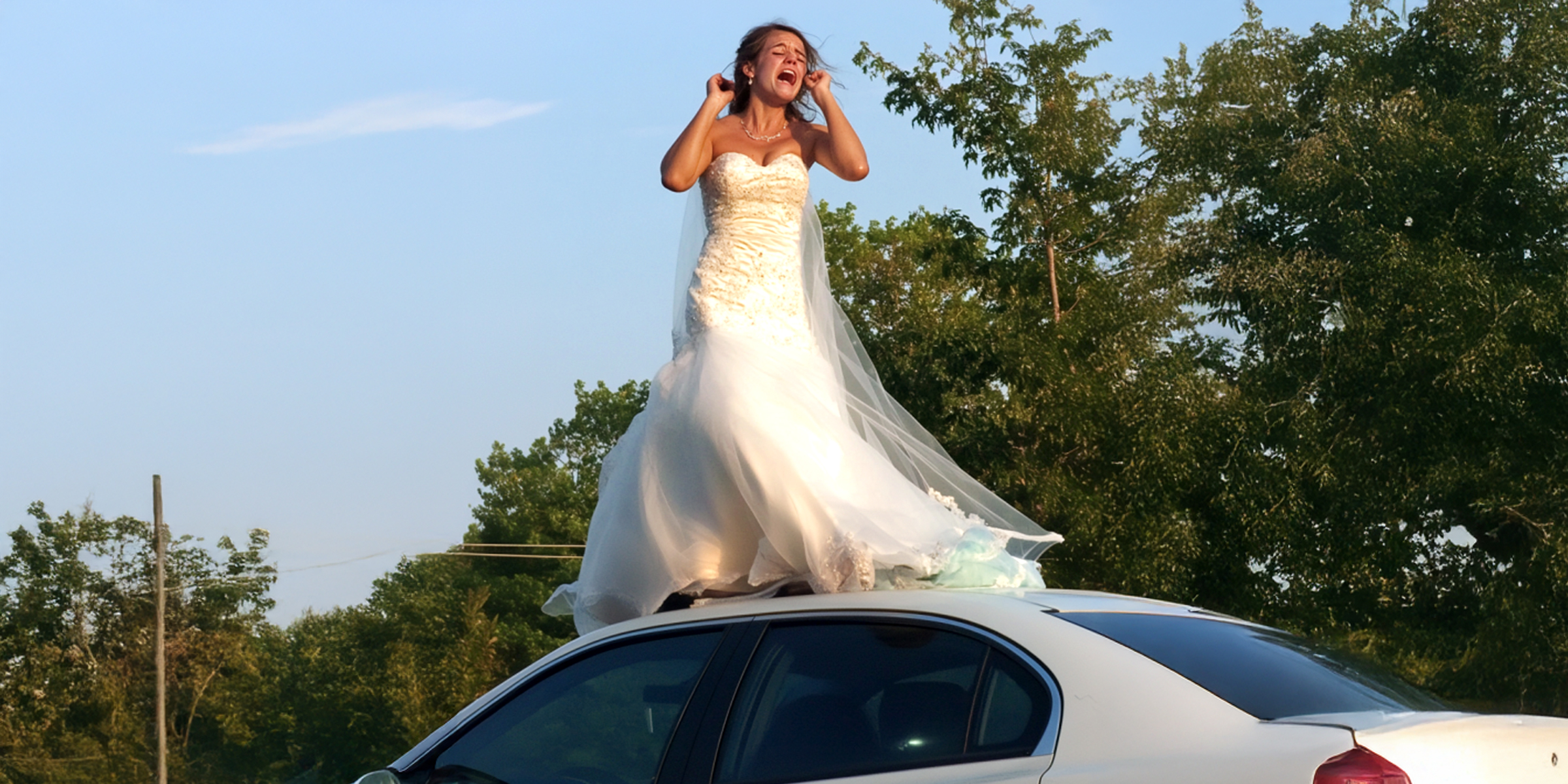 Une femme en robe de mariée debout sur le toit d'une voiture | Source : Amomama