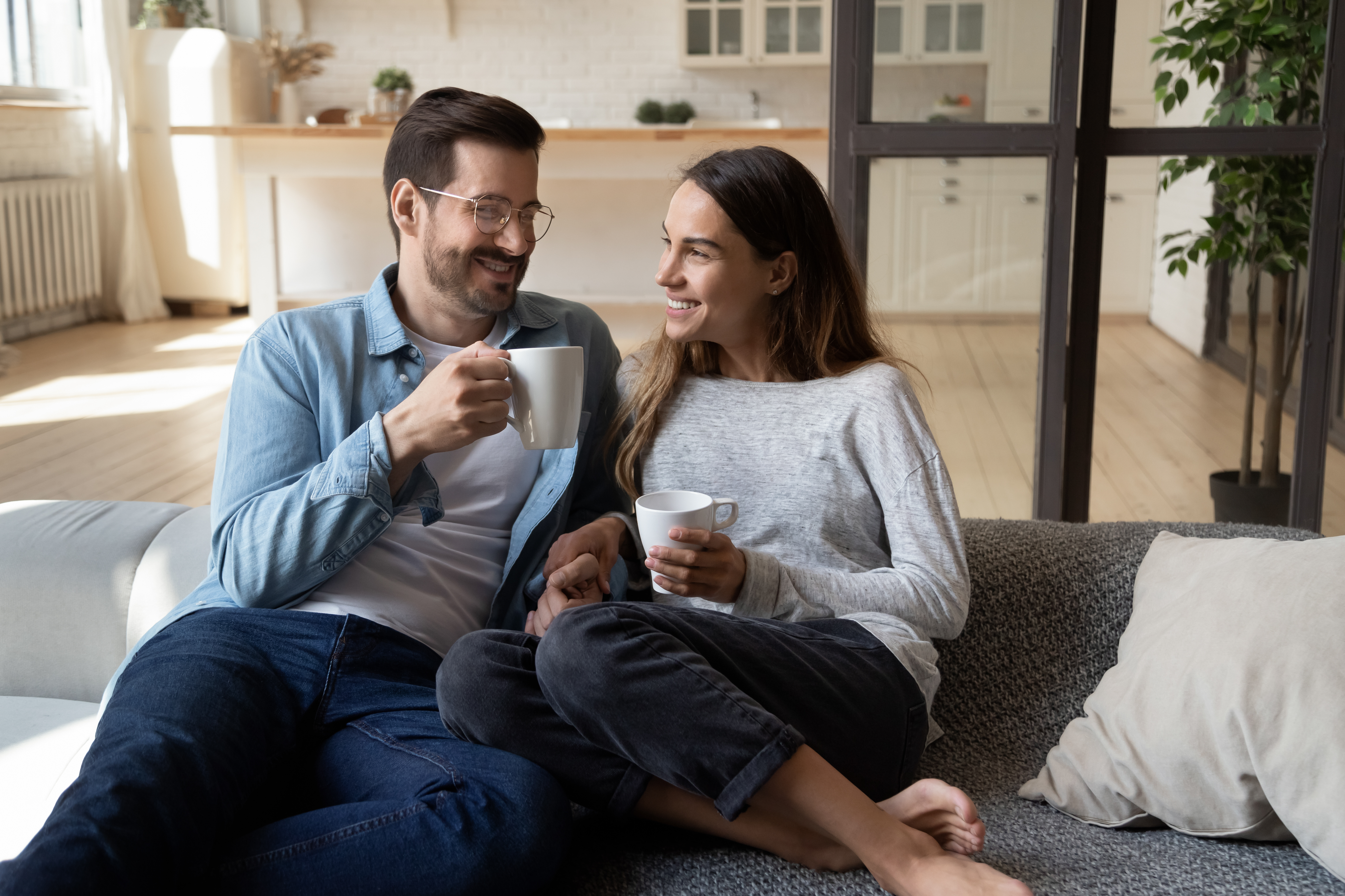 Un couple heureux qui boit du thé et se détend à la maison | Source : Shutterstock