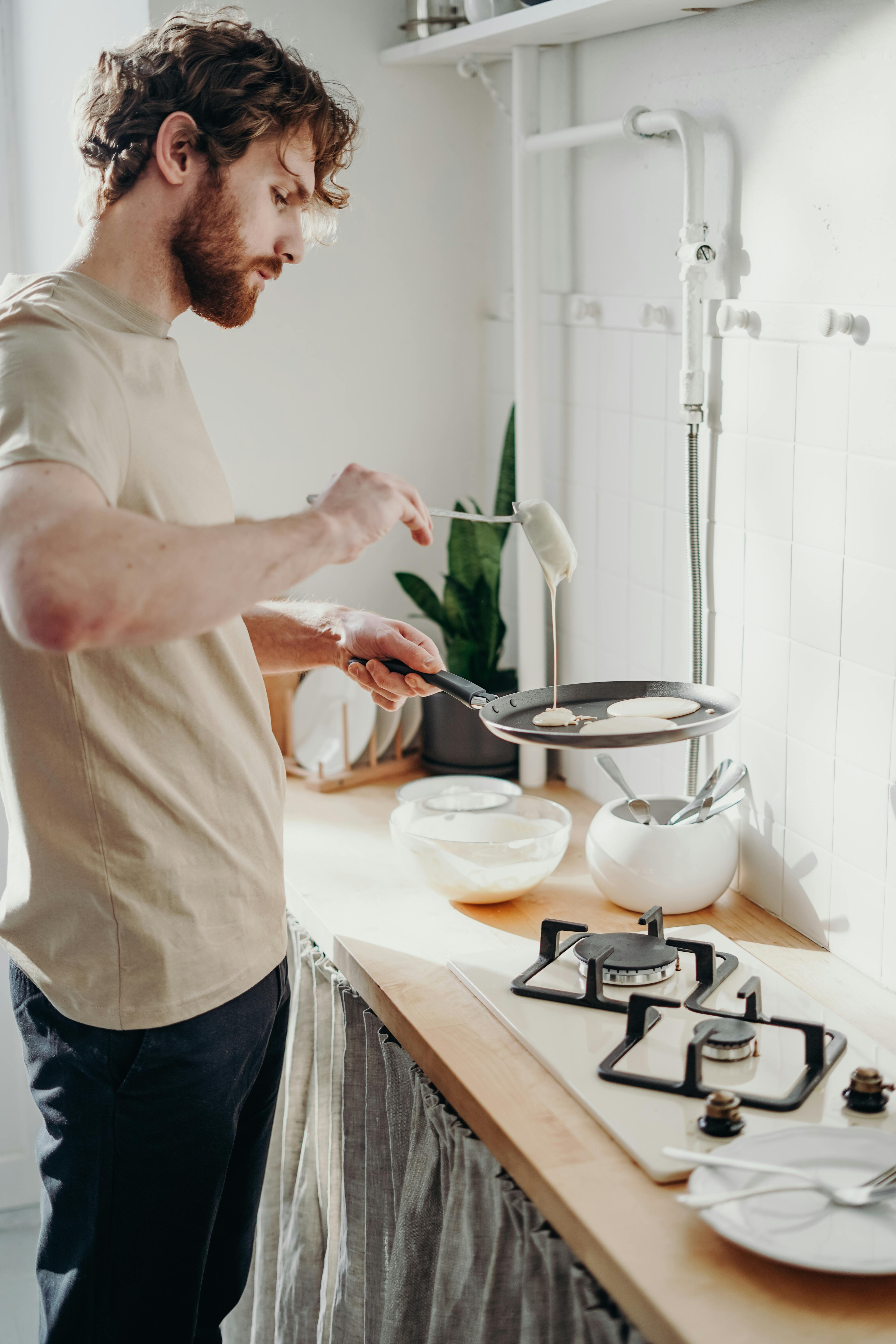 Un homme en train de préparer un repas devant un fourneau | Source : Pexels
