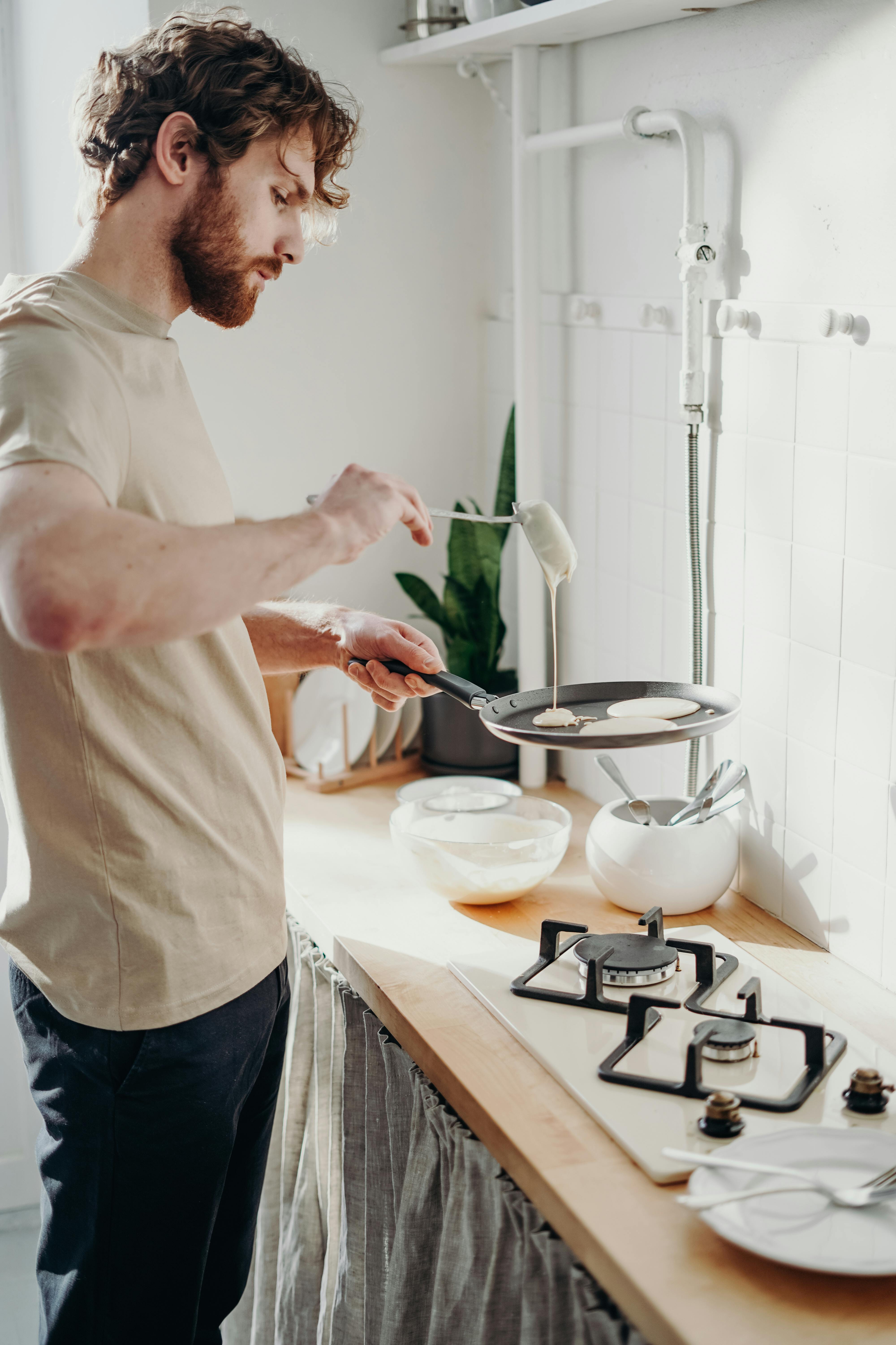 Ein Mann bereitet vor einem Herd eine Mahlzeit zu | Quelle: Pexels