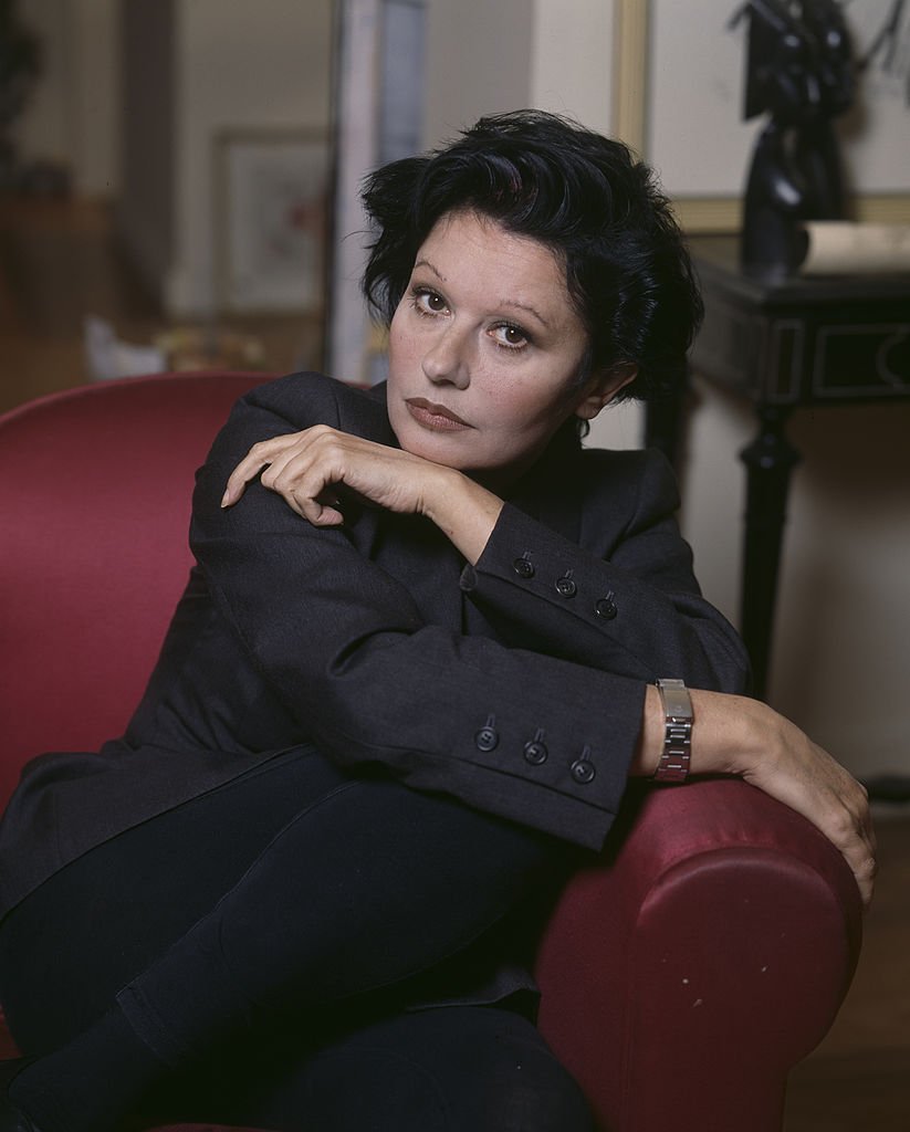 Patti Guesh à la maison. En France, en novembre 1992, Guesch PATTI, chanteuse, chez elle, assise dans un fauteuil dans le salon de son appartement. | Photo : Getty Images