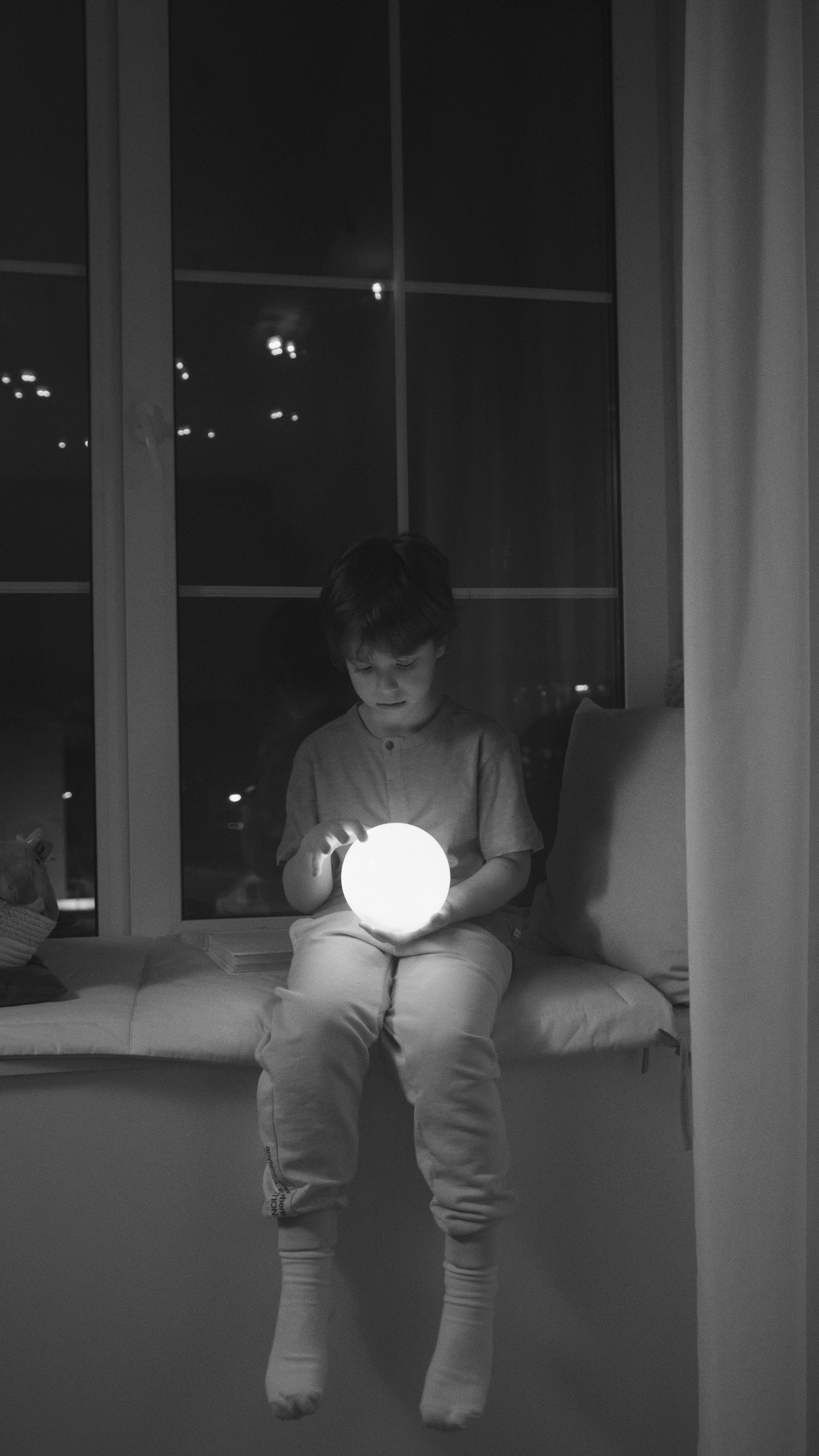 Un garçon tenant une boule de lumière | Source : Pexels