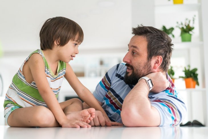 Un enfant qui discute avec son père | Photo : Shutterstock