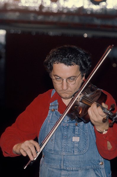 Coluche jouant du violon sur scène à Bobino le 23 novembre 1975 à Paris, France. | Photo : Getty Images