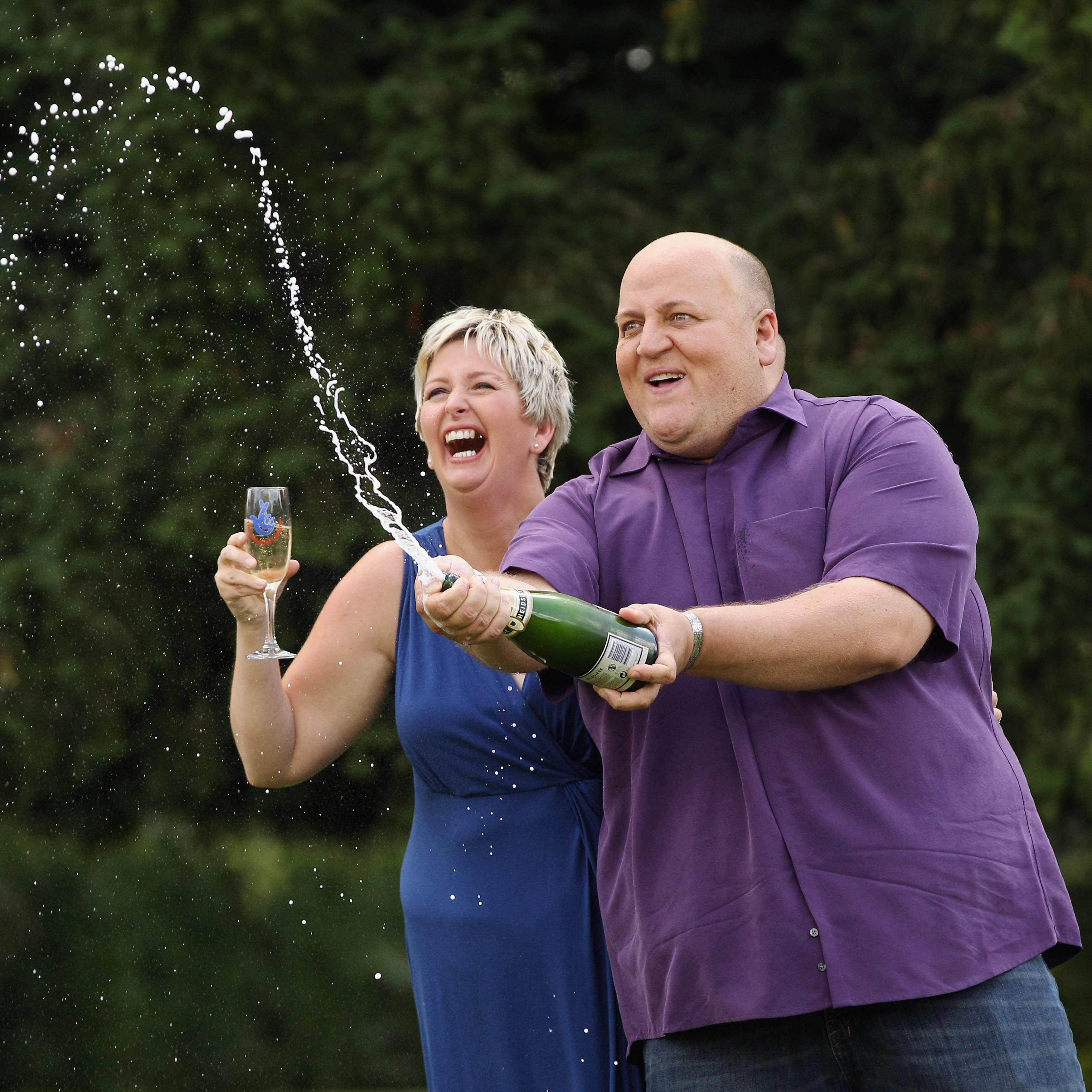 Gillian et Adrian Bayford célèbrent le fait d'avoir remporté le jackpot de plus de 148 millions de livres sterling à la loterie EuroMillions, le 14 août 2012, à Hatfield Heath, en Angleterre | Source : Getty Images