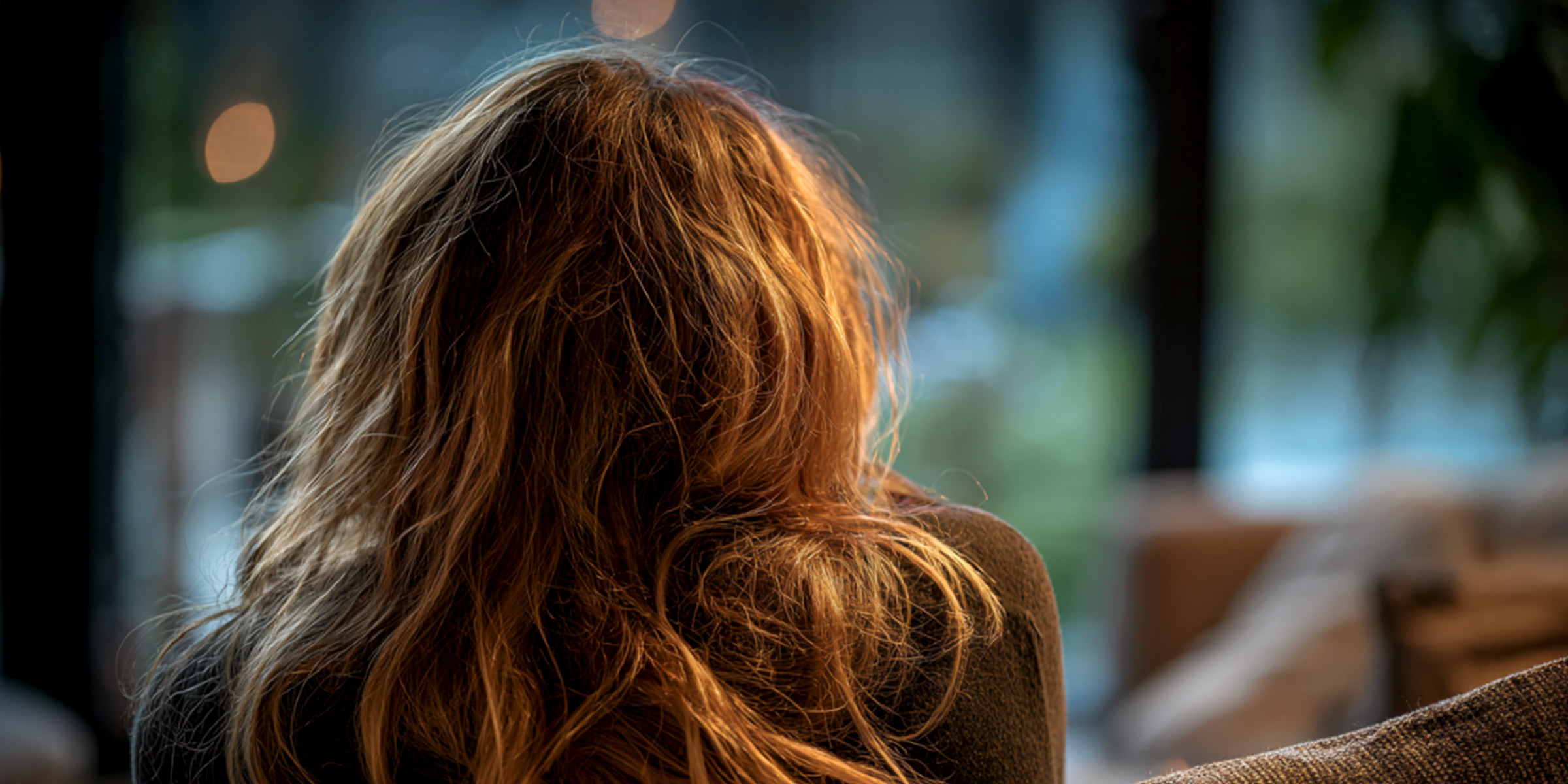 Une femme assise en silence regarde par la fenêtre, perdue dans ses pensées | Source : The Celebritist