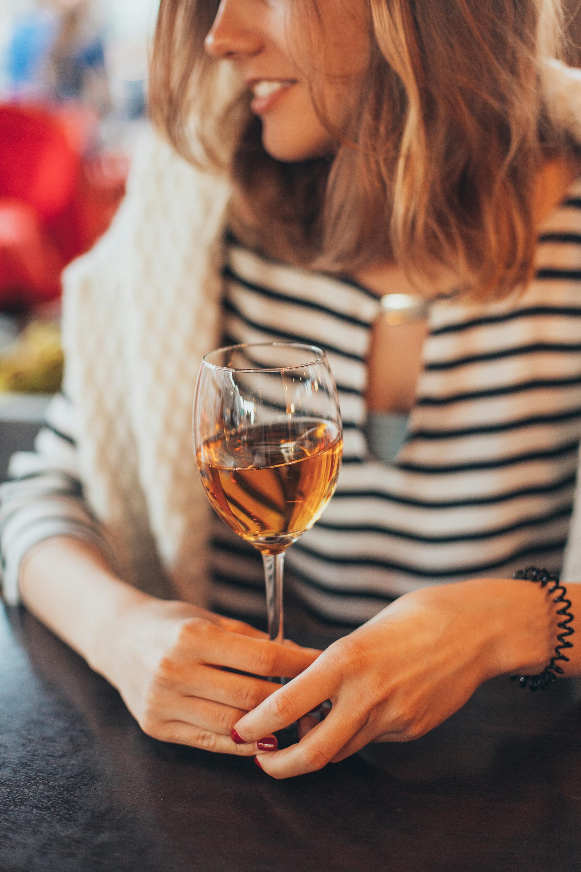 Une femme qui parle en tenant un verre | Source : Pexels