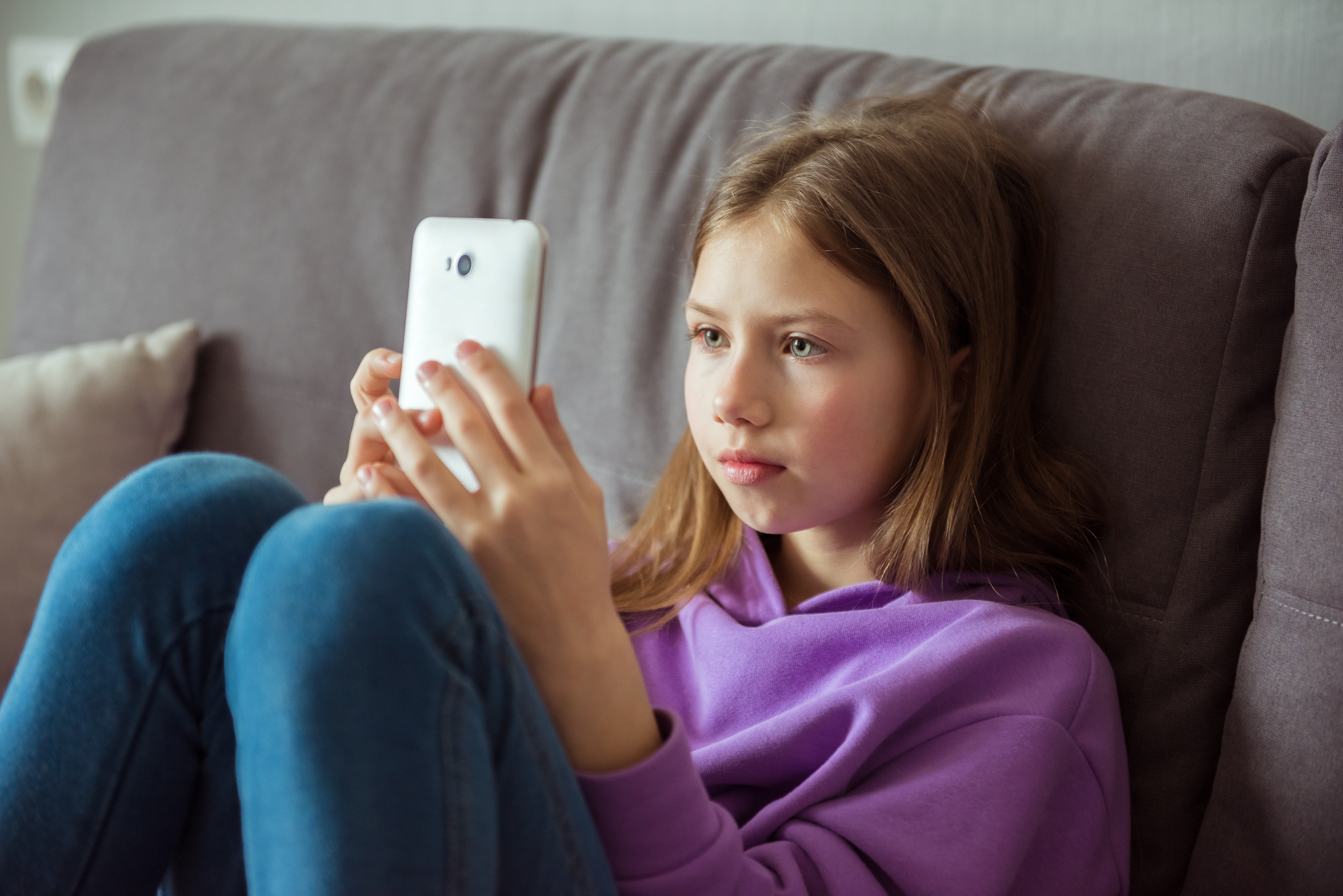Une adolescente tient un téléphone portable | Source : Shutterstock