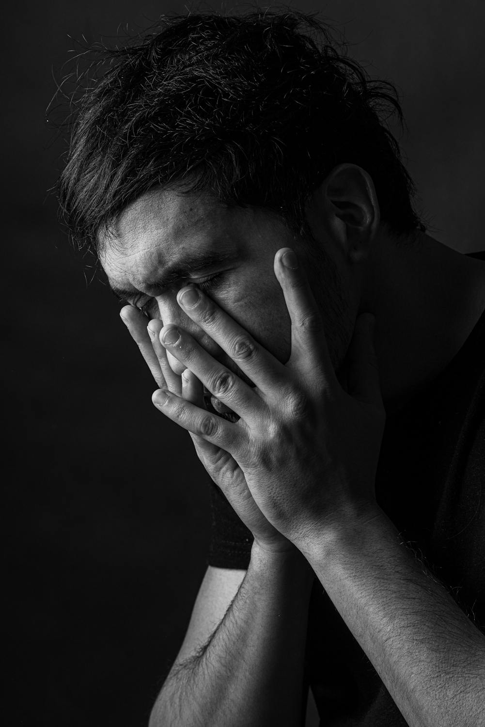 Un homme triste se couvrant le visage | Source : Pexels